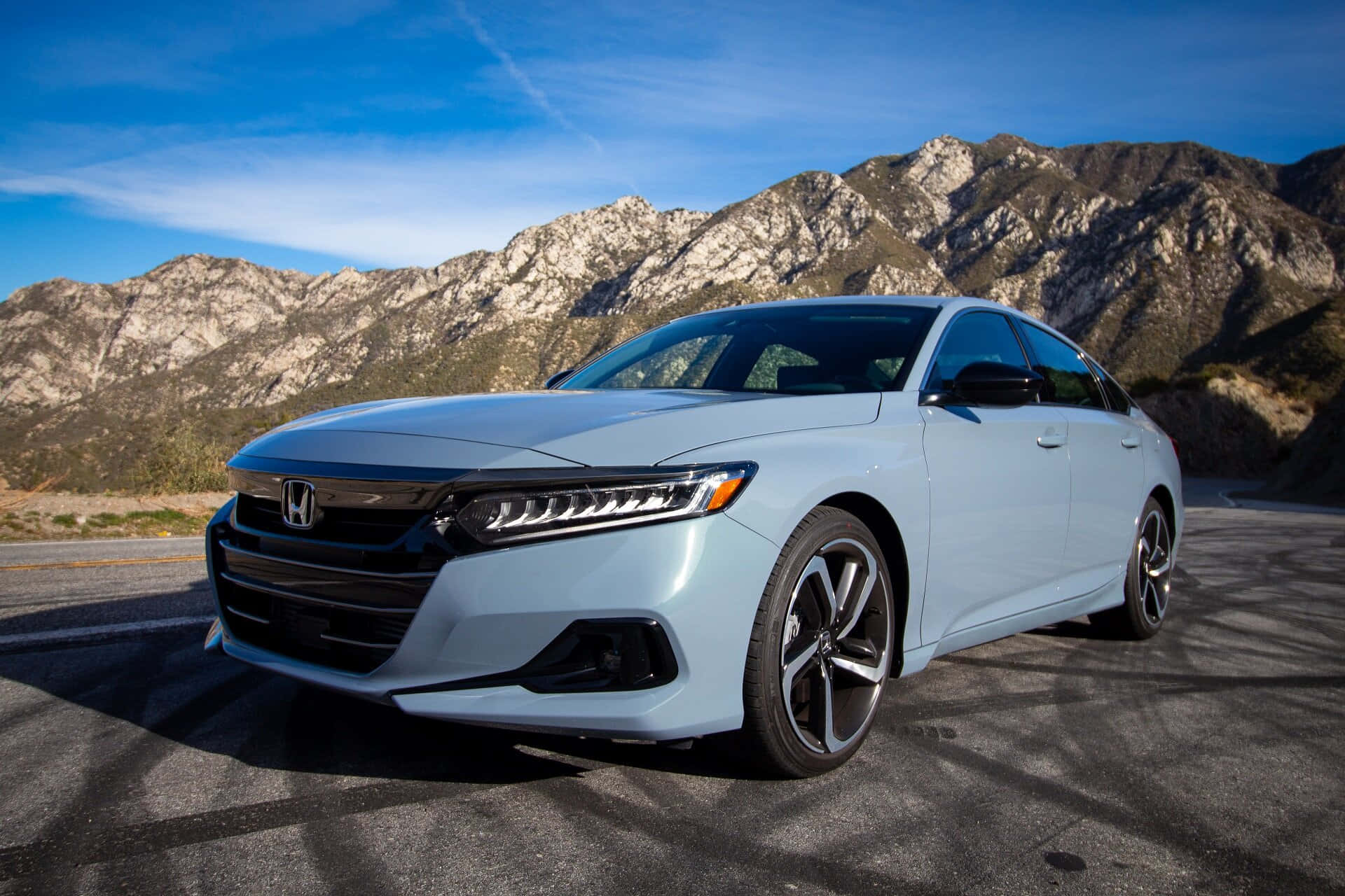Honda Accord 桌布 壁紙 — 一輛時尚的淺藍色本田轎車停在山路上，背景是晴朗的藍天和崎嶇的山峰。