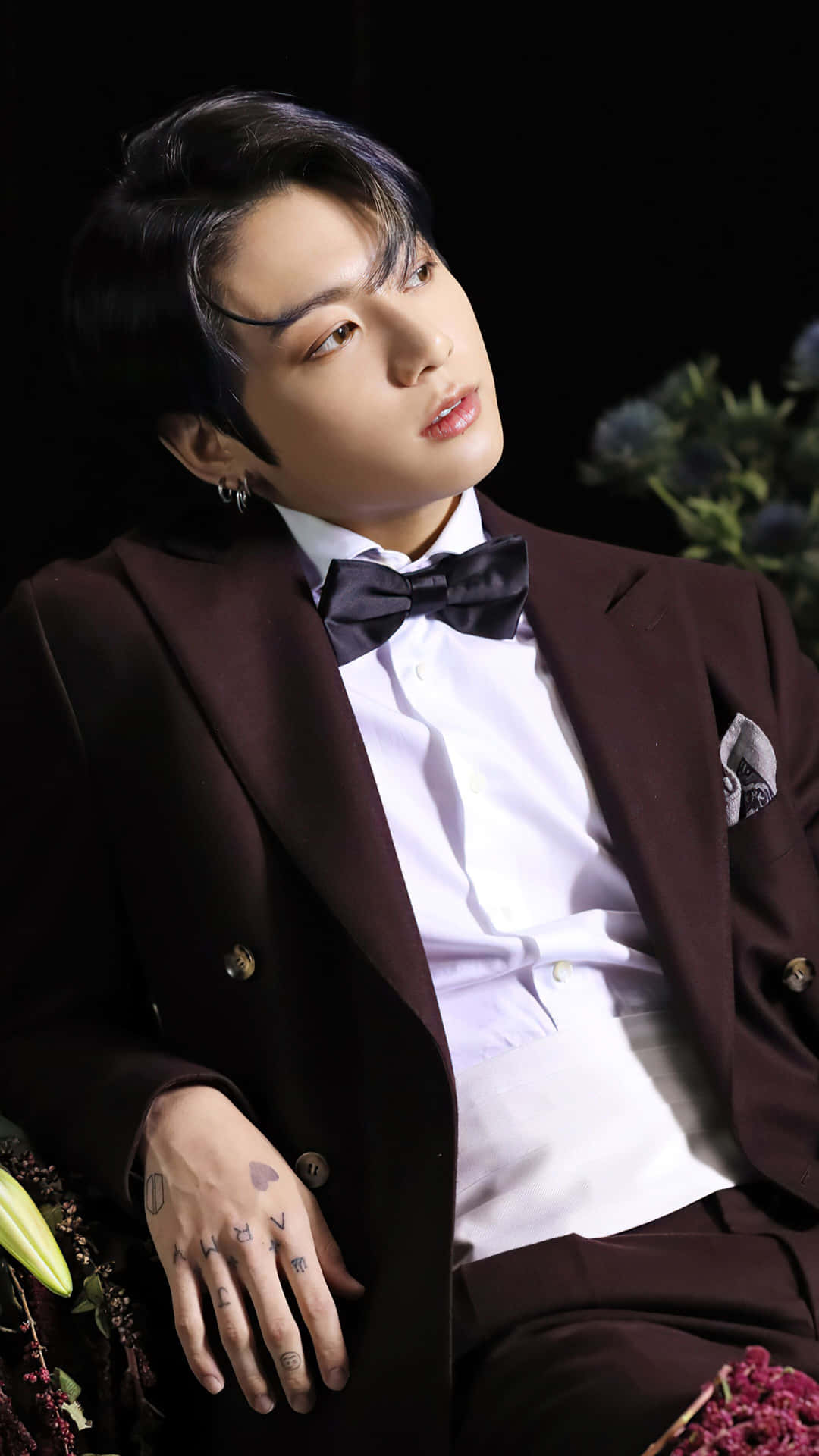 身穿栗色西裝、有紋身和領結的男士與鮮花合影 — Jungkook 壁紙