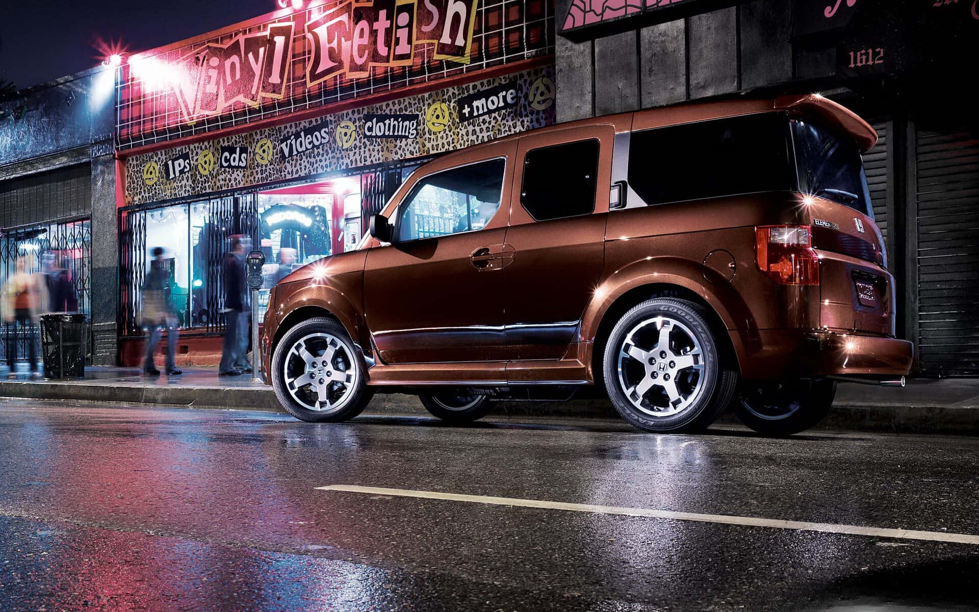 Honda Element 桌布 壁紙 — 一輛閃亮的青銅色SUV在夜間停放在濕漉漉的城市街道上，黑膠唱片店的霓虹燈下。