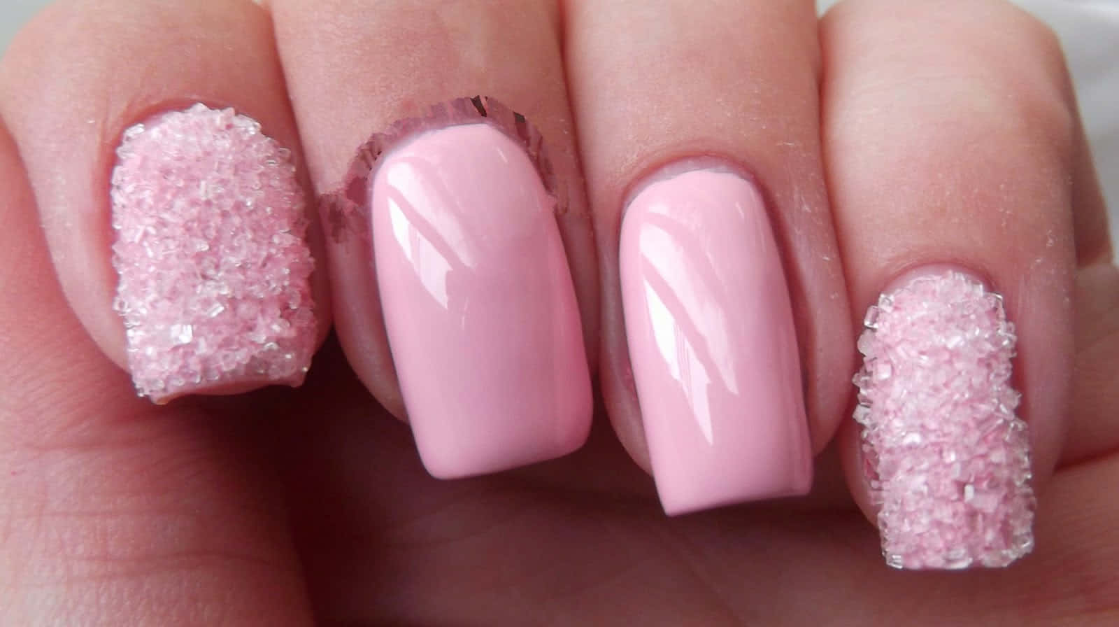 Pink Nails 桌布 壁紙 — 手部特寫，粉紅色指甲上飾有閃閃發光的糖狀亮片。