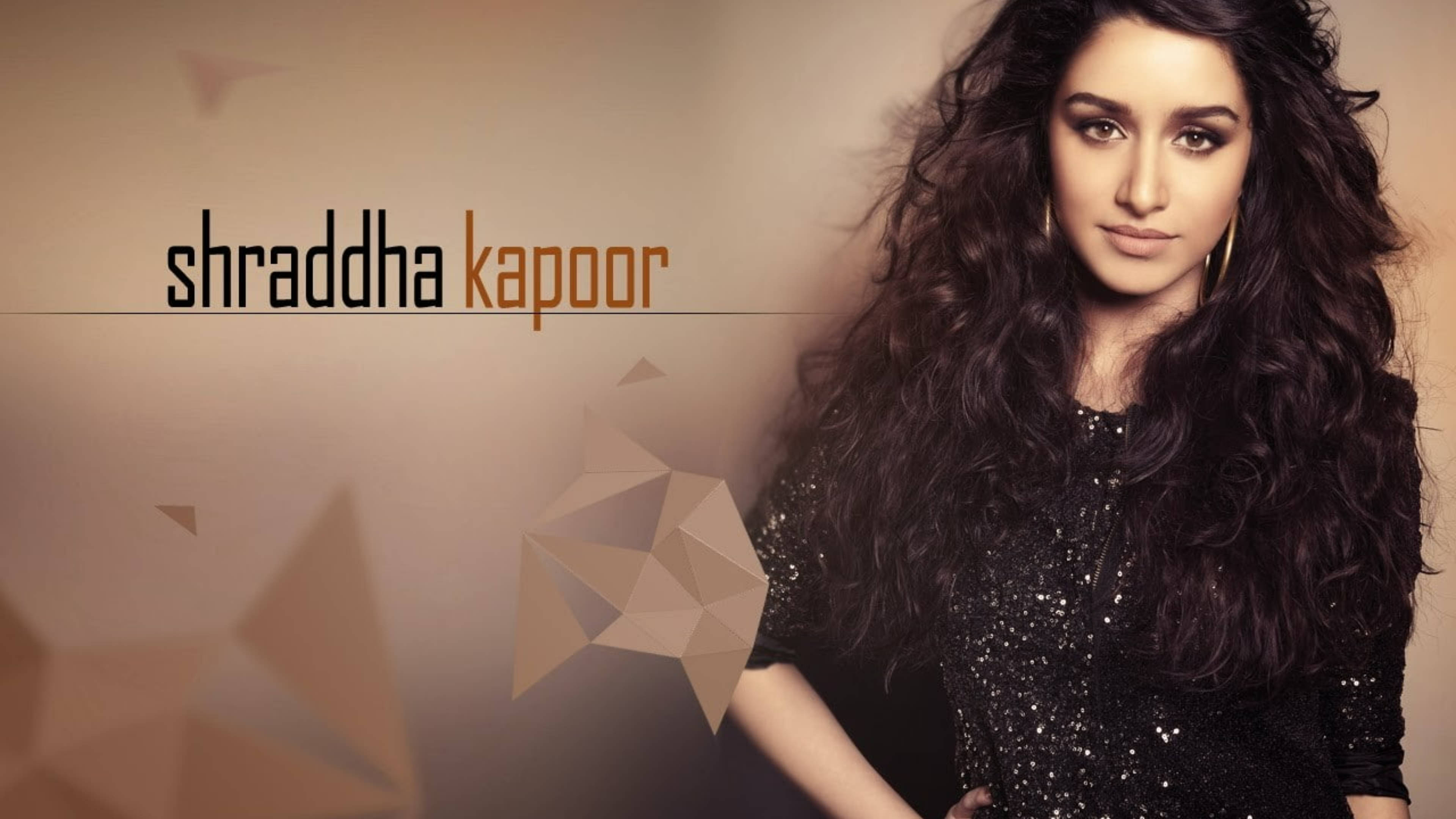 Shraddha Kapoor 桌布 壁紙 — Shraddha Kapoor 自信地擺姿勢，身穿閃亮黑色上衣，背景是溫暖的幾何圖案，豐盈的深色捲髮勾勒出她的臉龐。