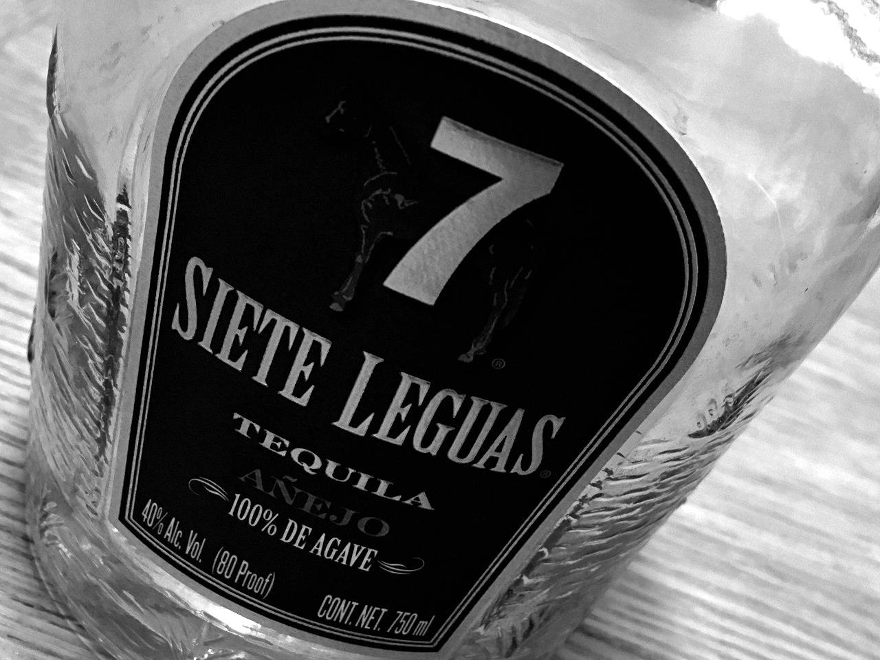 高清 桌布 壁紙 — Siете Leguas 龍舌蘭酒瓶標籤的特寫黑白照片，帶有馬的剪影和粗體字體。