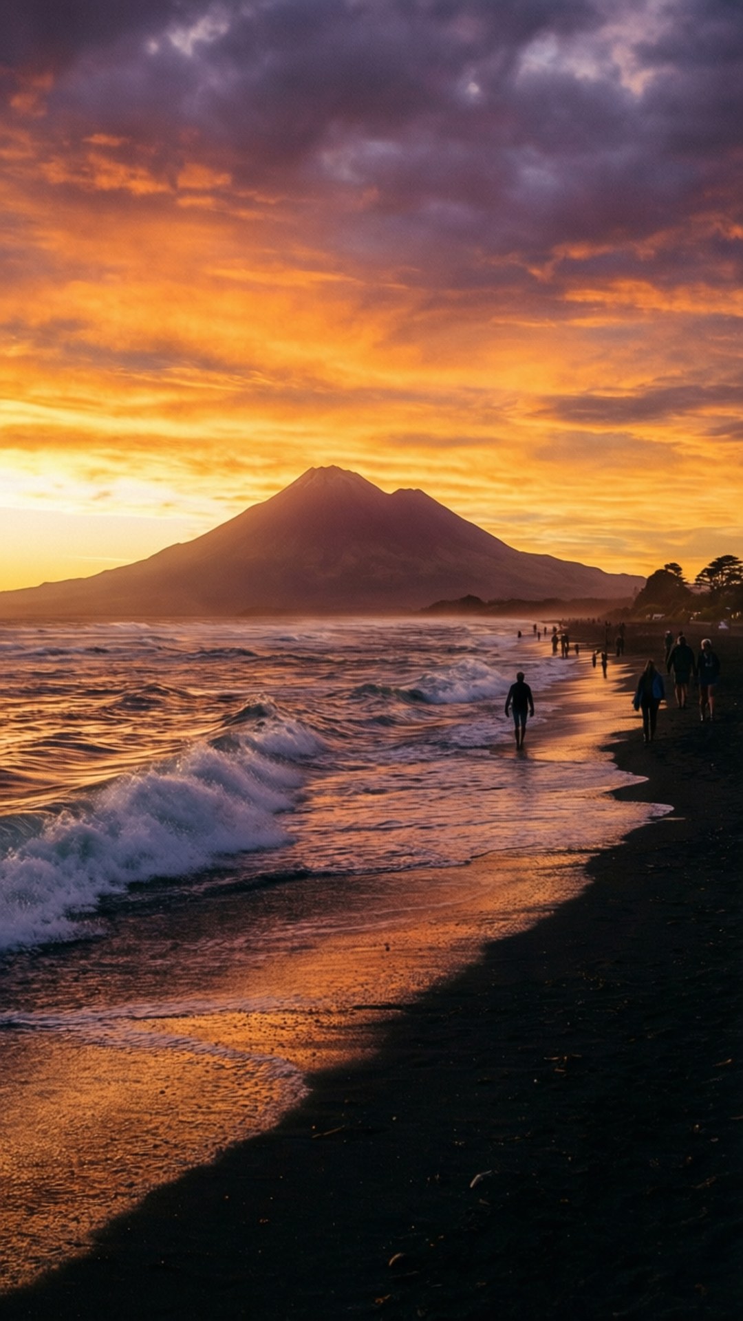 New Plymouth New Zealand 桌布 壁紙 — 剪影人物在黑色沙灘上漫步，海浪在遠山後方火紅橙紫的夕陽下拍打。