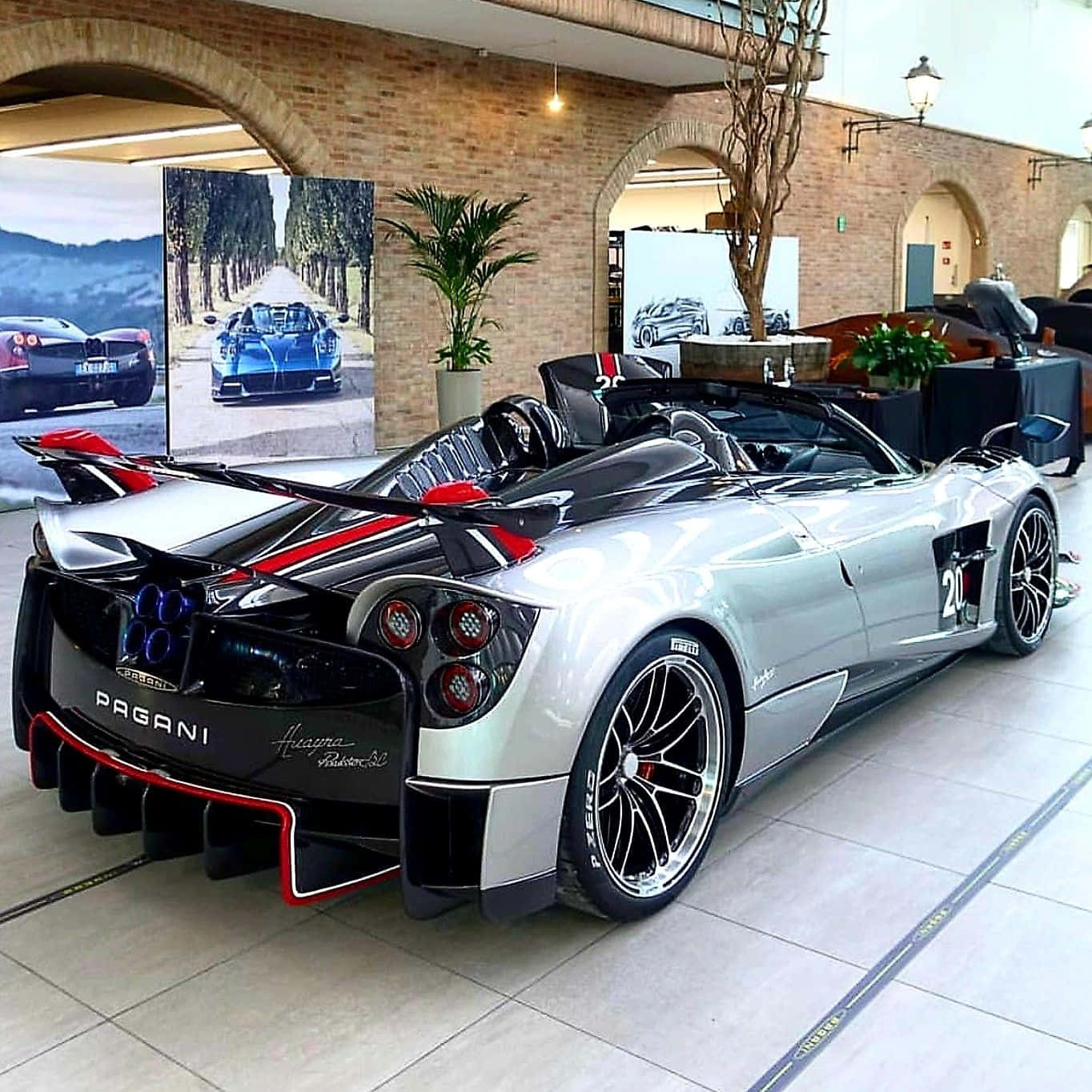 Pagani Zonda C12 Roadster 桌布 壁紙 — 一輛銀黑色Pagani Huayra Roadster 3D帶紅色點綴，在豪華展示間中，在磚拱門和盆栽植物下，於明亮燈光下閃耀。