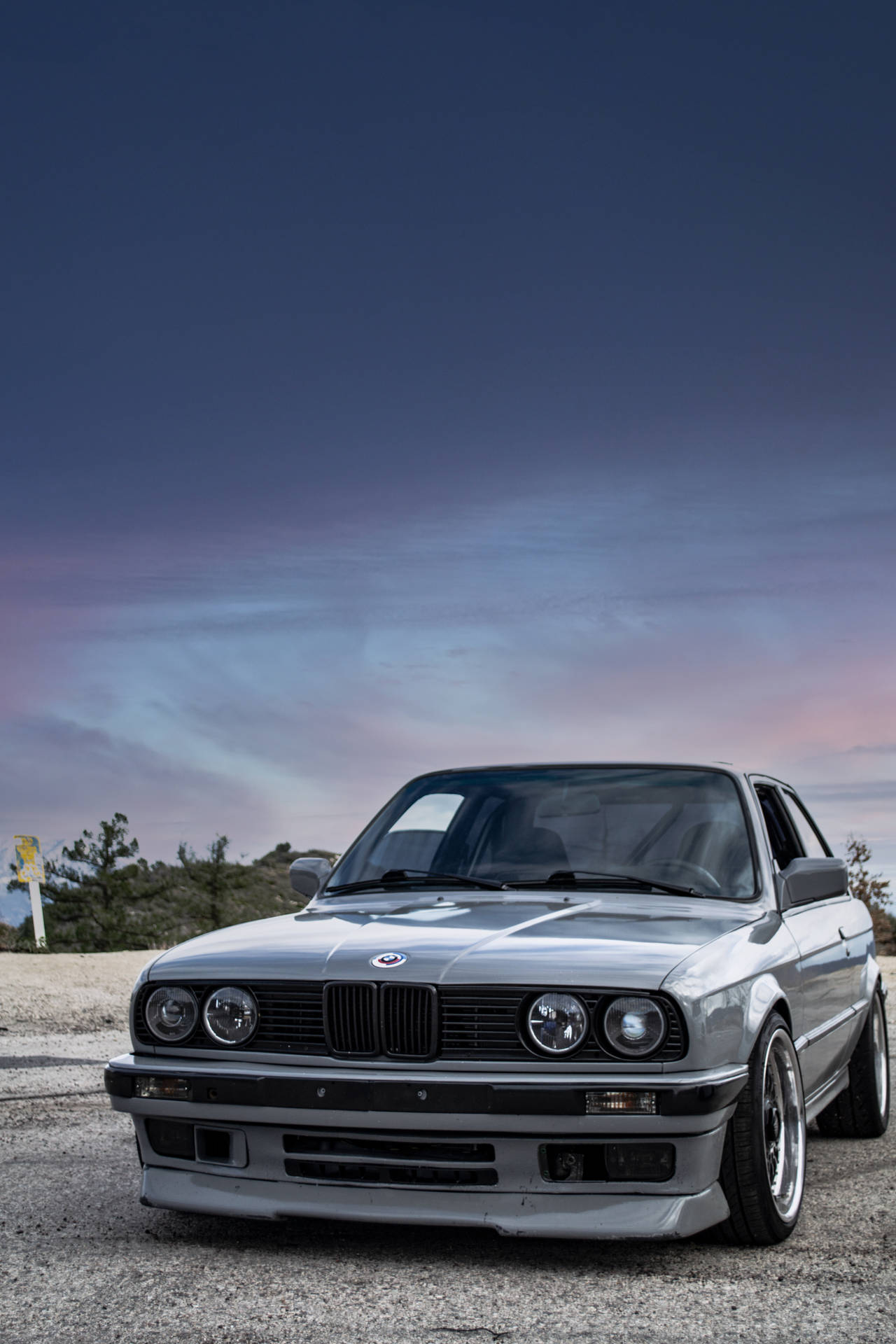 暮色中銀色BMW E30雙門轎跑車停在碎石上。 — 4K 超高清 壁紙