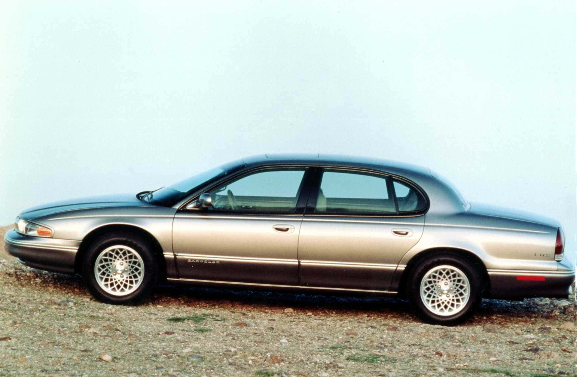 Chrysler Lhs 桌布 壁紙 — 一輛銀色別克路霸四門房車停在礫石上，天空蒼白，線條簡潔，帶有鍍鉻裝飾。