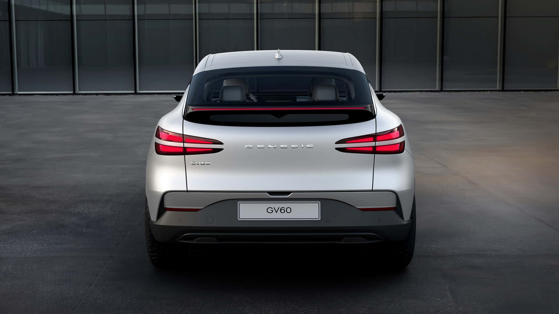 夜間城市環境中銀色 Genesis GV60 電動 SUV 後視圖。 — Toyota Supra Mk4 壁紙