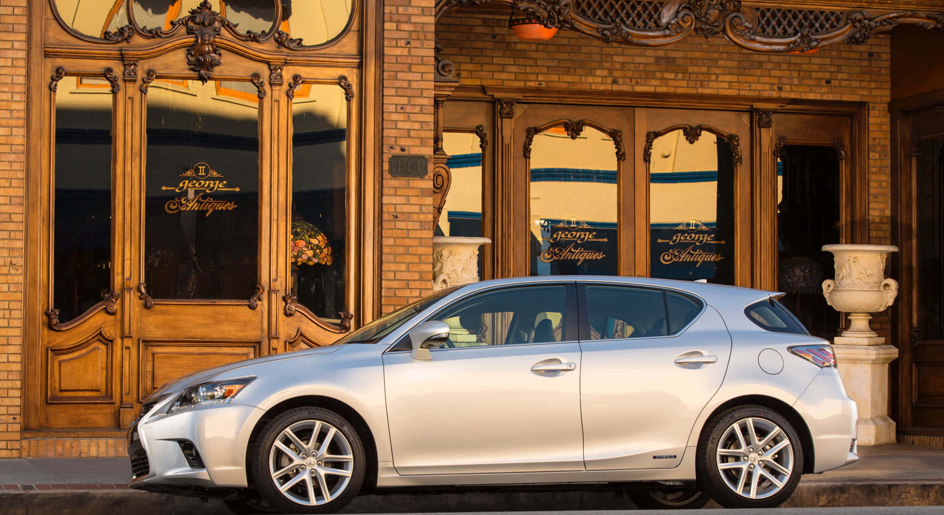 Lexus Ct 200h 桌布 壁紙 — 一輛銀色Lexus掀背車停在華麗的磚砌建築前，建築有復古木門和裝飾甕。