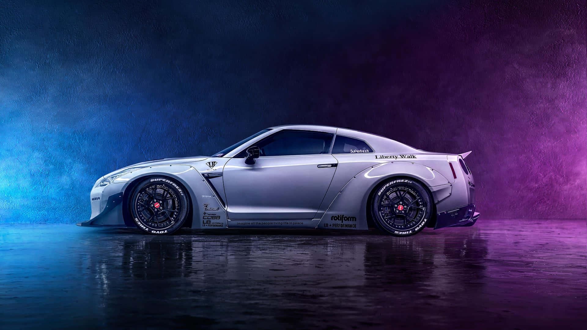  壁紙 — 一輛銀色 Liberty Walk 日產 GT-R 跑車，配備黑色輪圈和定制車身套件，在藍色和紫色燈光下的反射濕地工作室中展示。