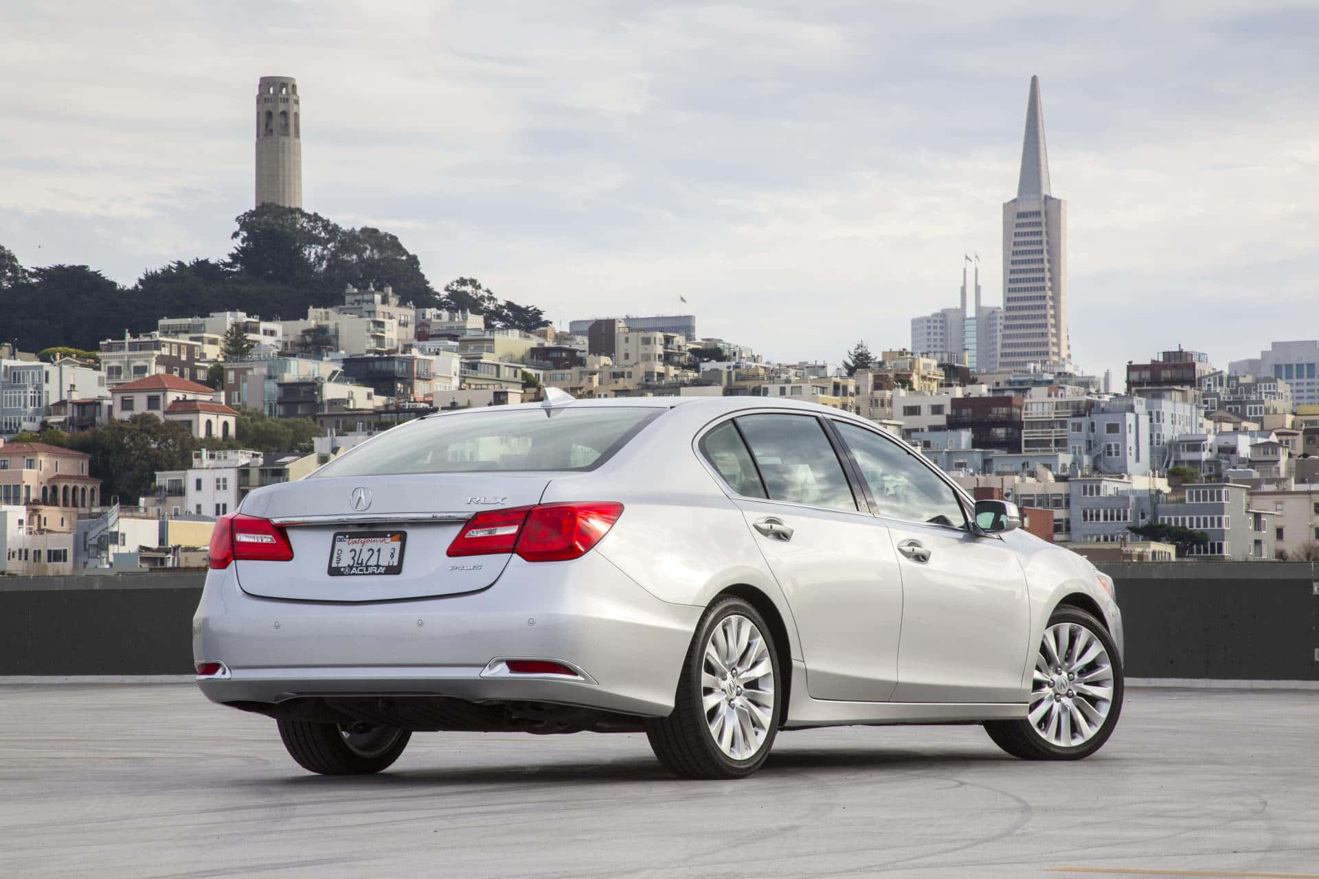 Acura Rlx 桌布 壁紙 — 一輛銀色轎車停泊在屋頂上，俯瞰舊金山標誌性的天際線，可見科伊特塔和泛美金字塔。