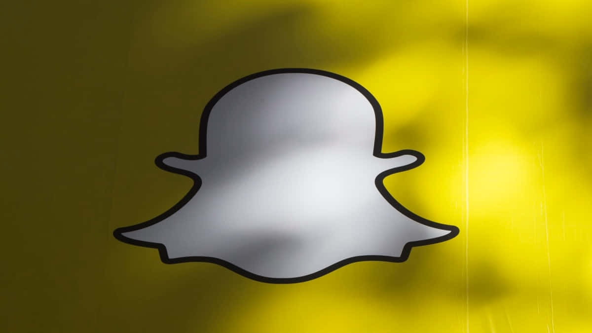  壁紙 — 一個帶有黑色輪廓的銀色Snapchat鬼魂標誌，在帶有柔和陰影的鮮黃色背景上脫穎而出。