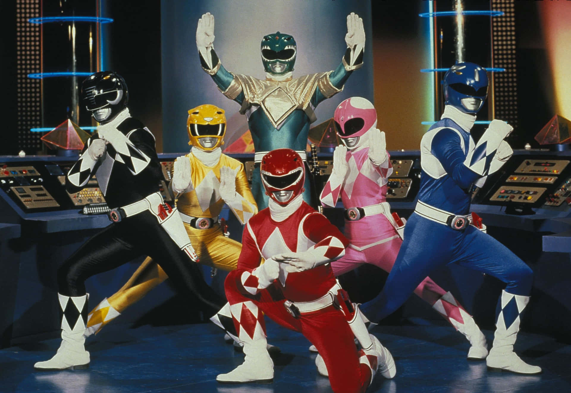  壁紙 — 六位身穿色彩繽紛戰衣的Power Rangers在一個高科技指揮中心內擺出英雄姿勢。