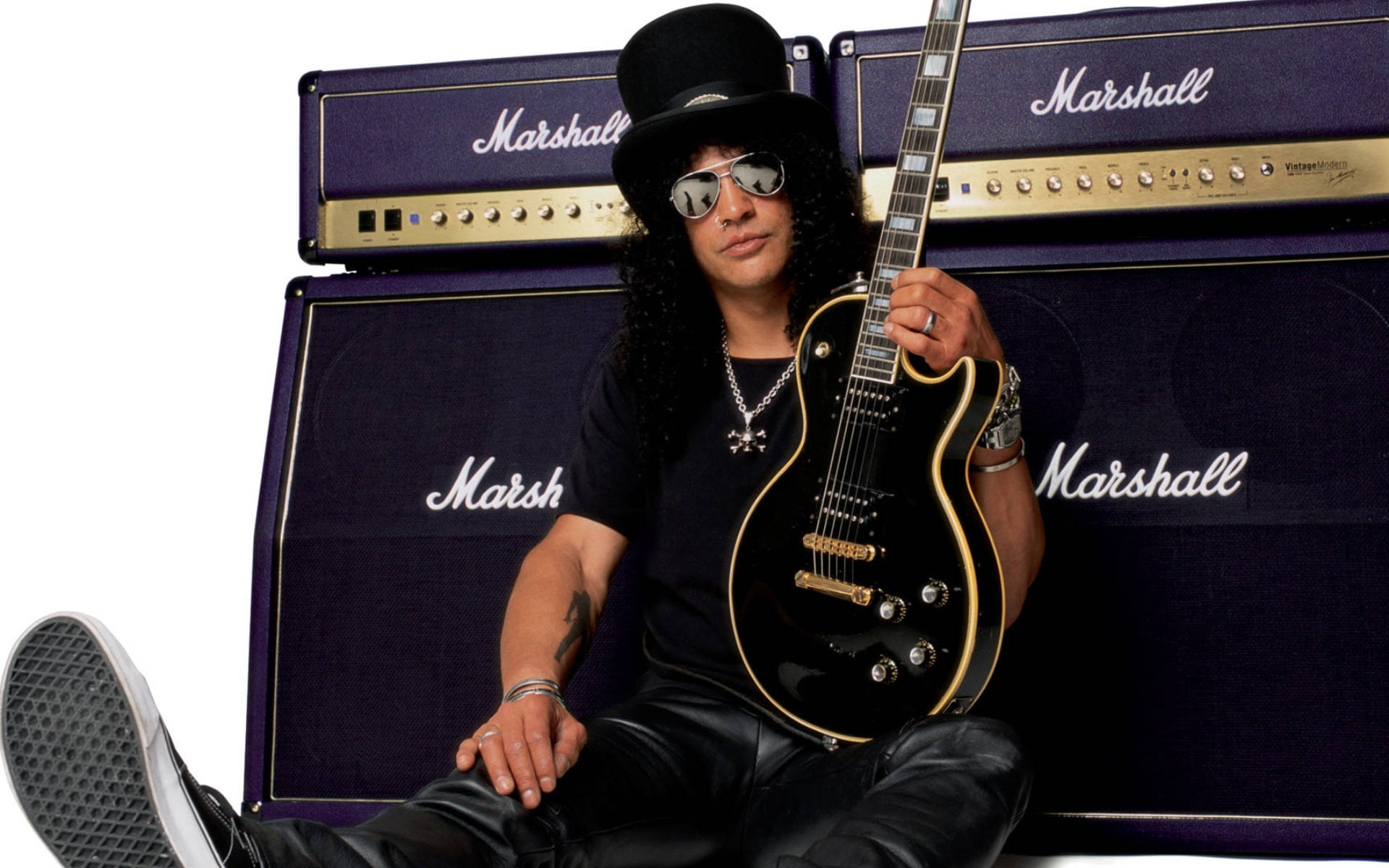 Marshall 桌布 壁紙 — Slash 隨意地坐著，戴著高帽和太陽眼鏡，手持黑色電吉他，背後是紫色 Marshall 擴音器。