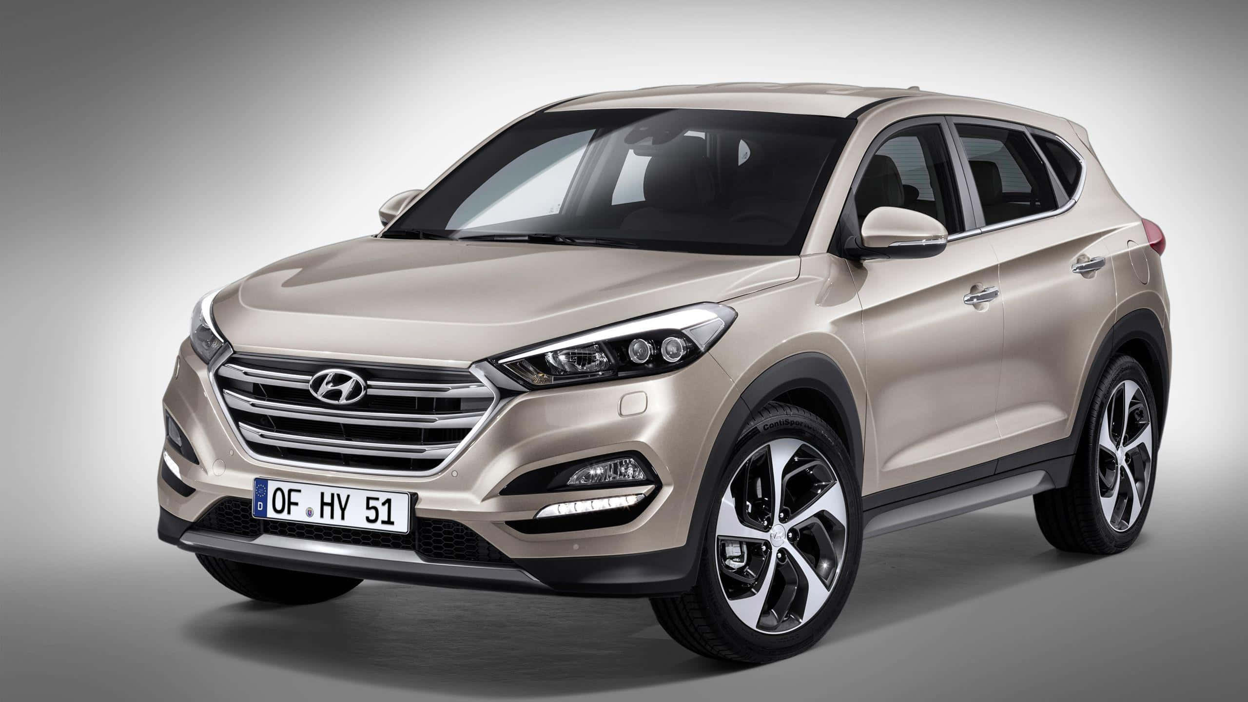Hyundai Tucson 桌布 壁紙 — 一輛時尚的米色Hyundai Tucson SUV在工作室中展示，配有柔和燈光和漸變灰色背景。
