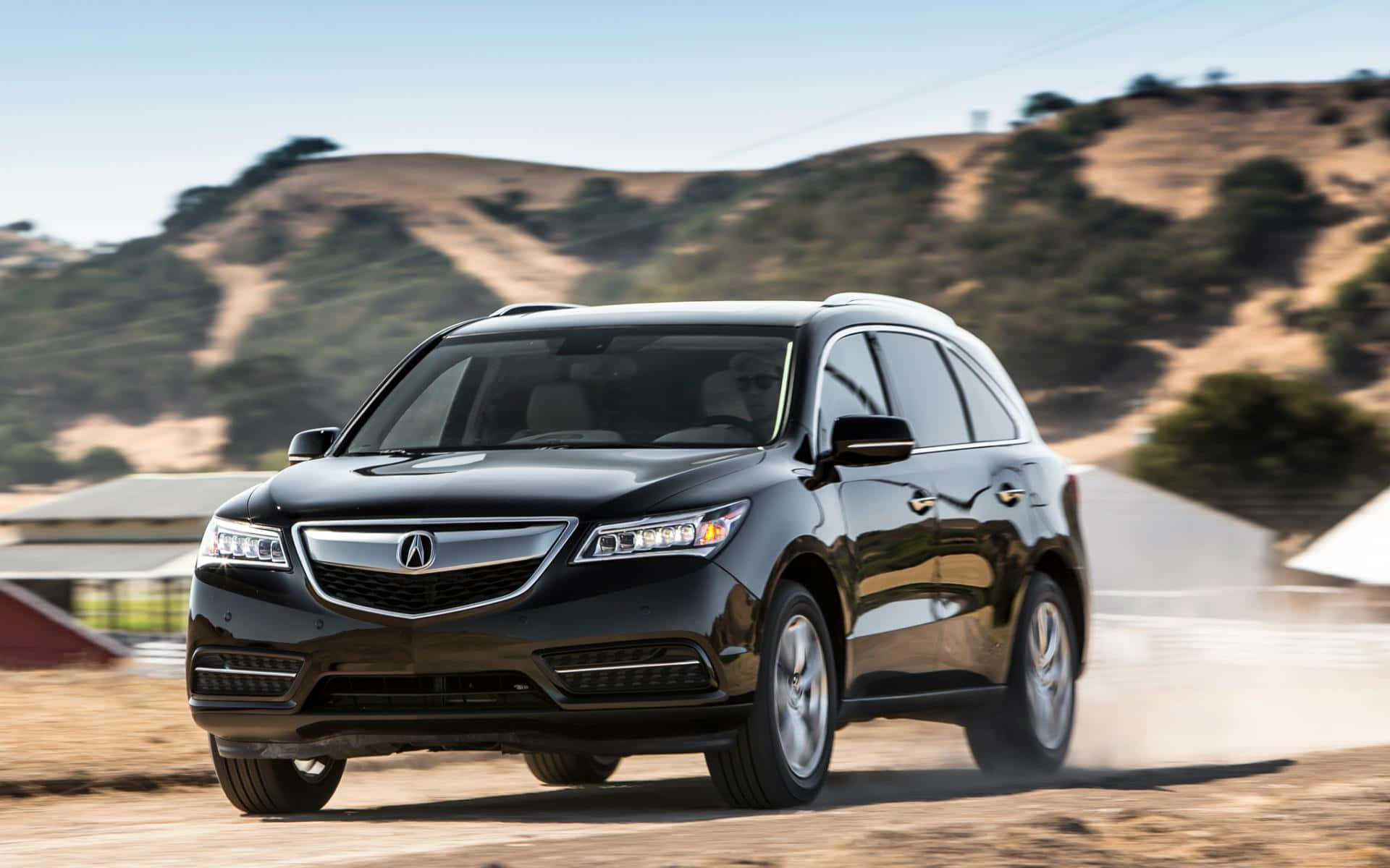Acura Mdx 桌布 壁紙 — 一輛時尚的黑色Acura SUV在塵土飛揚的鄉村道路上強勁行駛，背景是起伏的山丘。