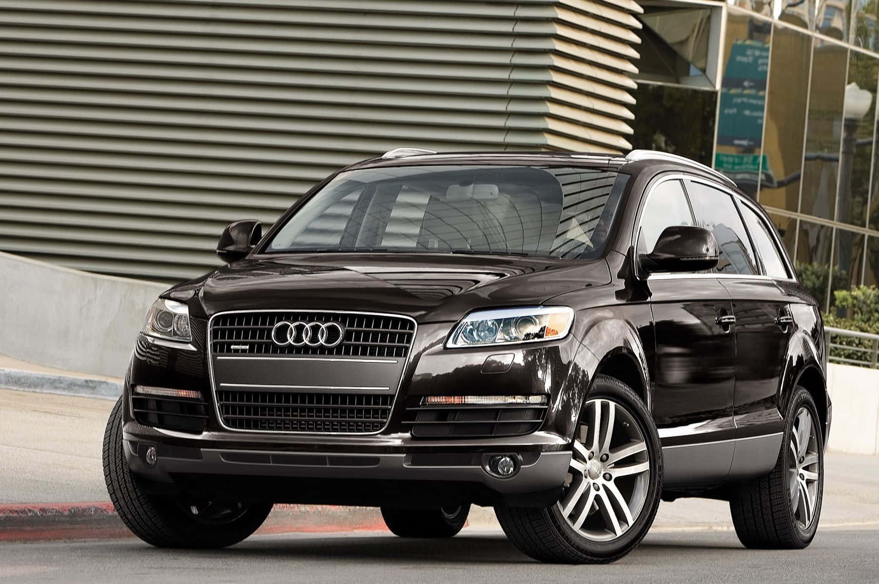 Audi Q7 桌布 壁紙 — 一輛時尚的黑色奧迪Q7 SUV停放在城市街道上，背景是現代建築。