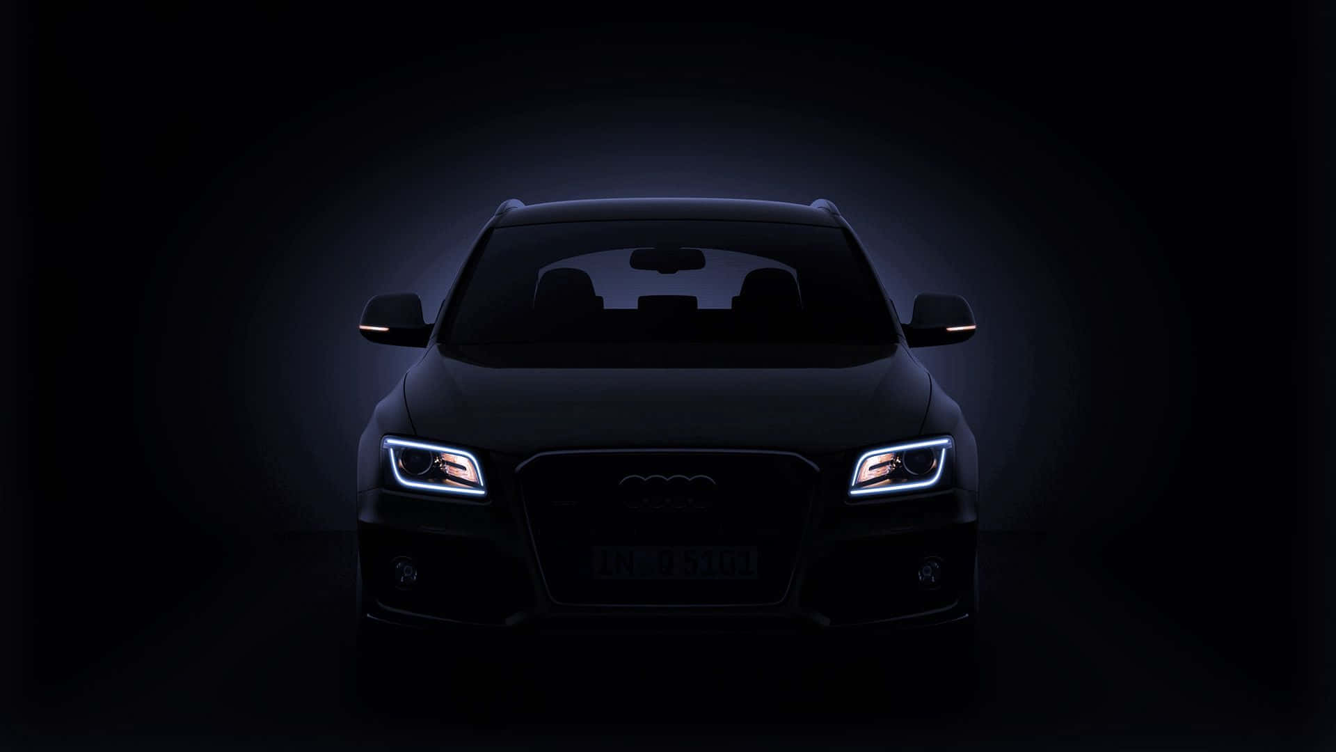Audi Q5 桌布 壁紙 — 一輛時尚的黑色奧迪SUV在黑暗的攝影棚背景下，散發著銳利的LED頭燈光芒。