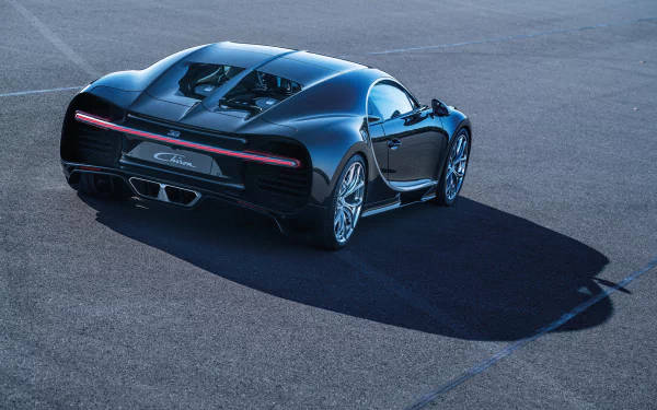 黑色Bugatti Chiron跑車停在人行道上，投下長長的影子。 — 4K 壁紙