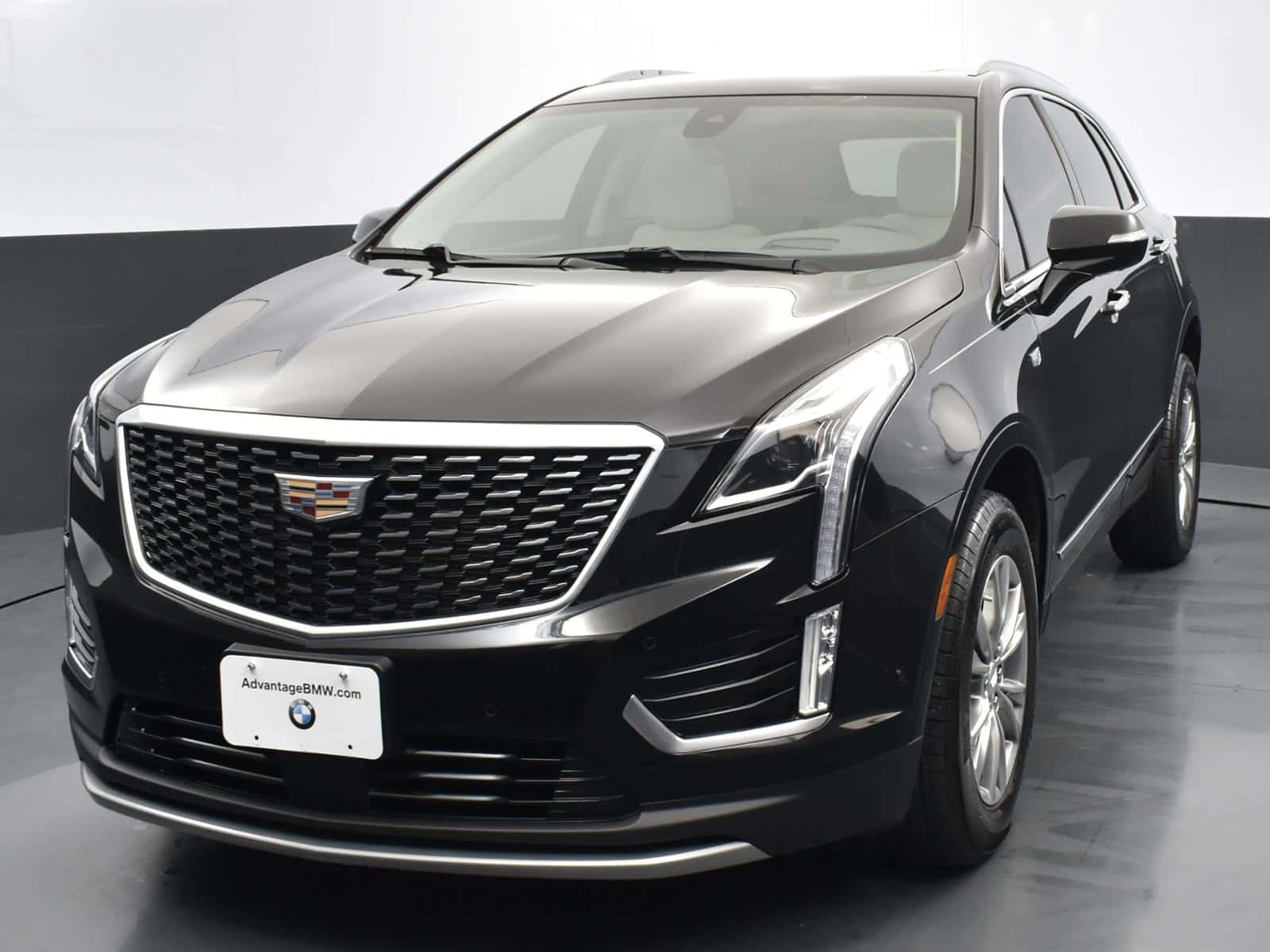 Cadillac Xt5 桌布 壁紙 — 一輛時尚的黑色凱迪拉克XT5 SUV在極簡風格的工作室中展示，配有反射地板和中性牆壁。