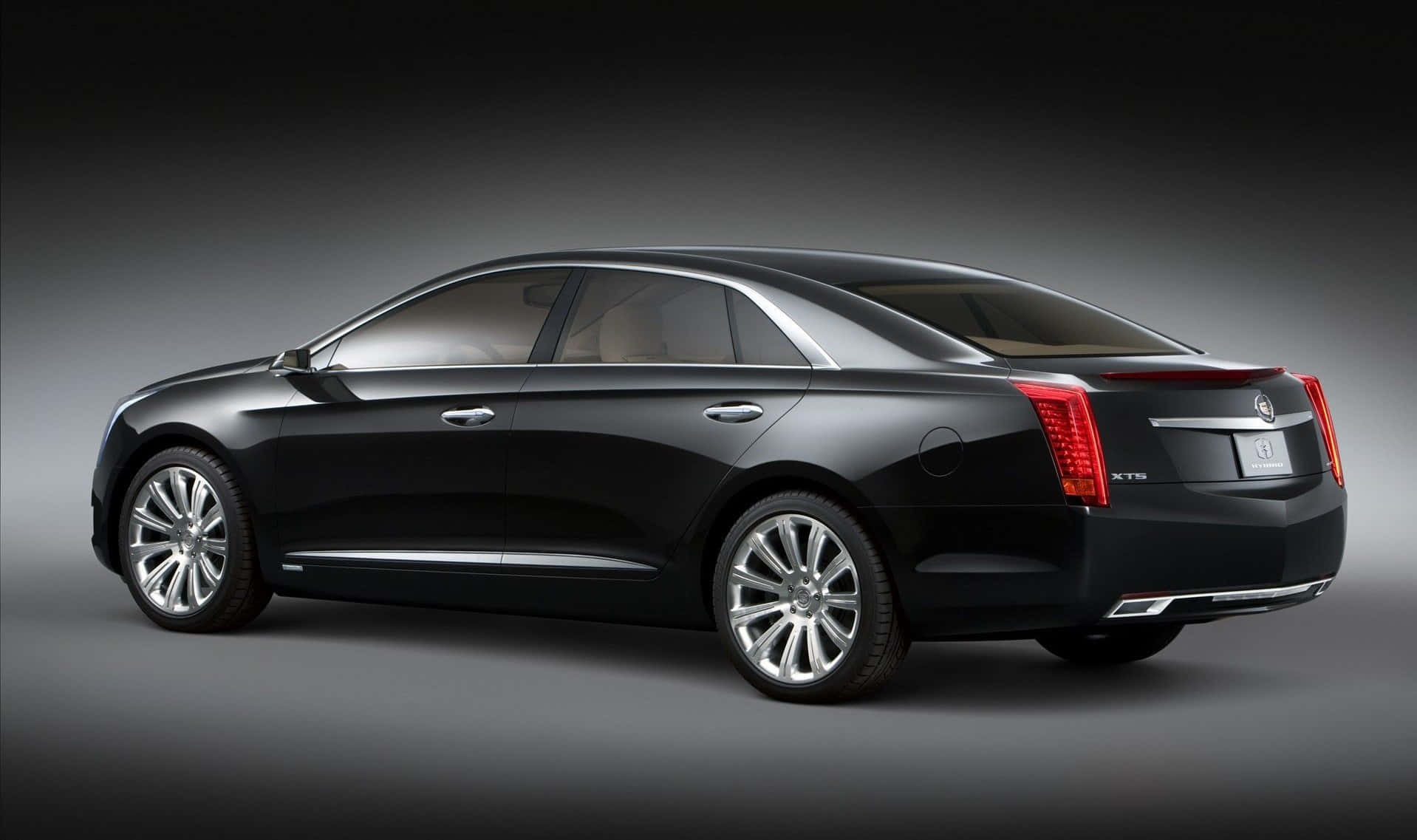Cadillac Xts 桌布 壁紙 — 一輛時尚的黑色Cadillac XTS轎車在深色漸變工作室背景中以側面展示，配備拋光鍍鉻輪圈。