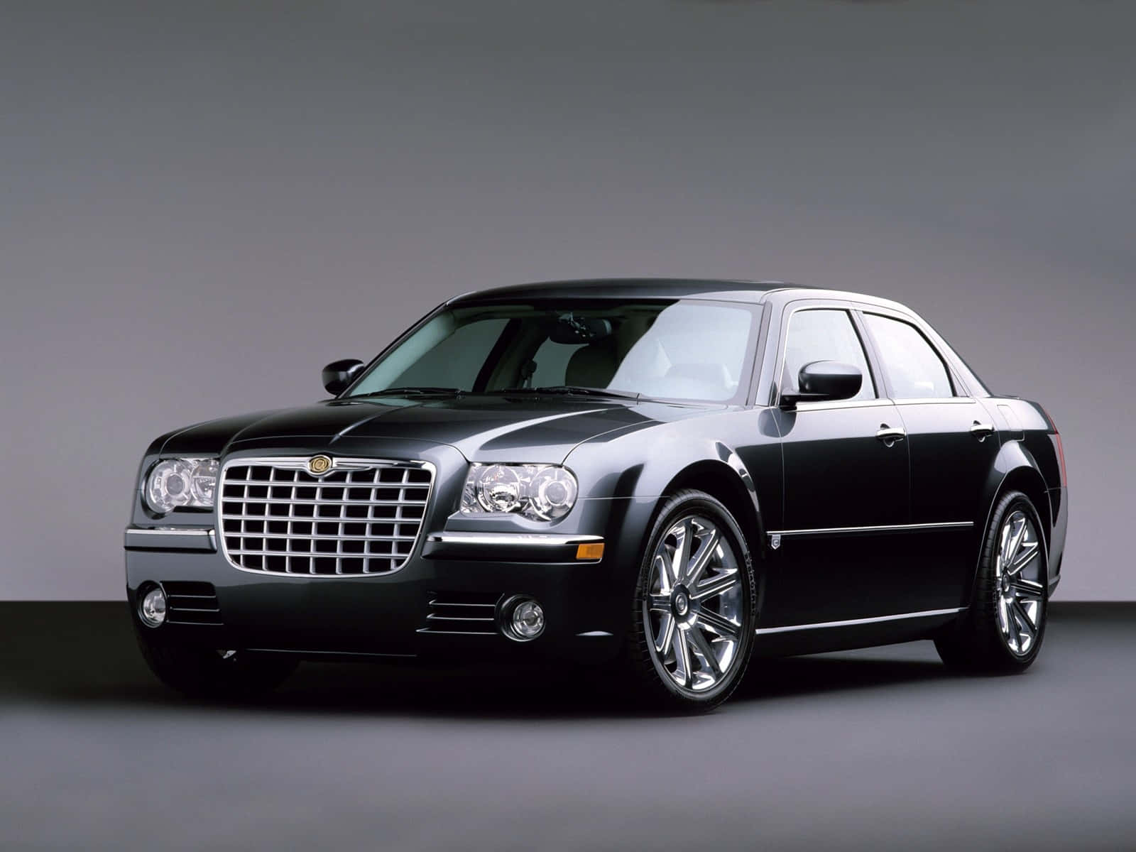 Chrysler 300 桌布 壁紙 — 一輛時尚的黑色Chrysler 300轎車在攝影棚燈光下閃耀，背景是簡約的灰色。