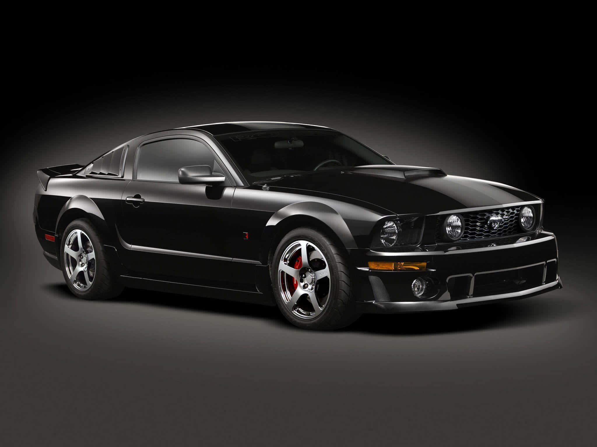 Ford Mustang Roush 桌布 壁紙 — 一輛時尚的黑色福特野馬跑車，配備紅色制動卡鉗和銀色輪圈，在深色工作室背景下展示。