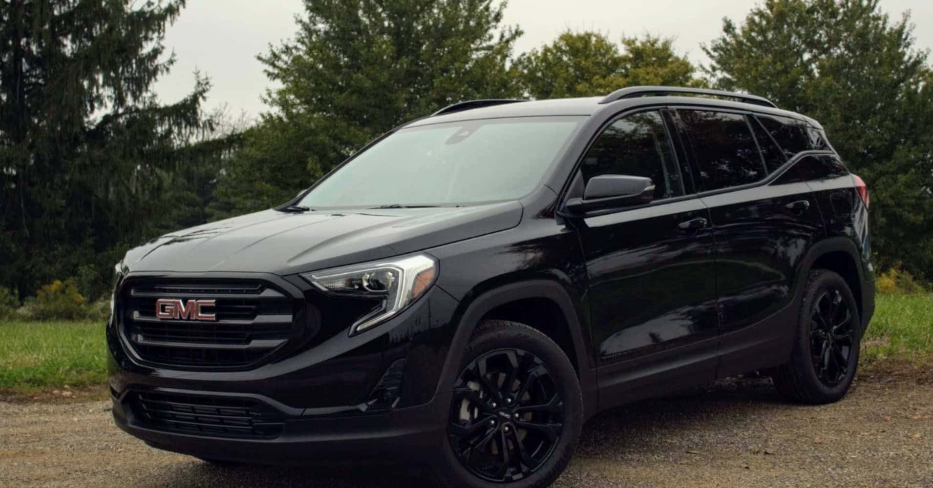 Gmc Terrain 桌布 壁紙 — 一輛時尚的黑色GMC SUV停在碎石上，背景有樹木，天空多雲。