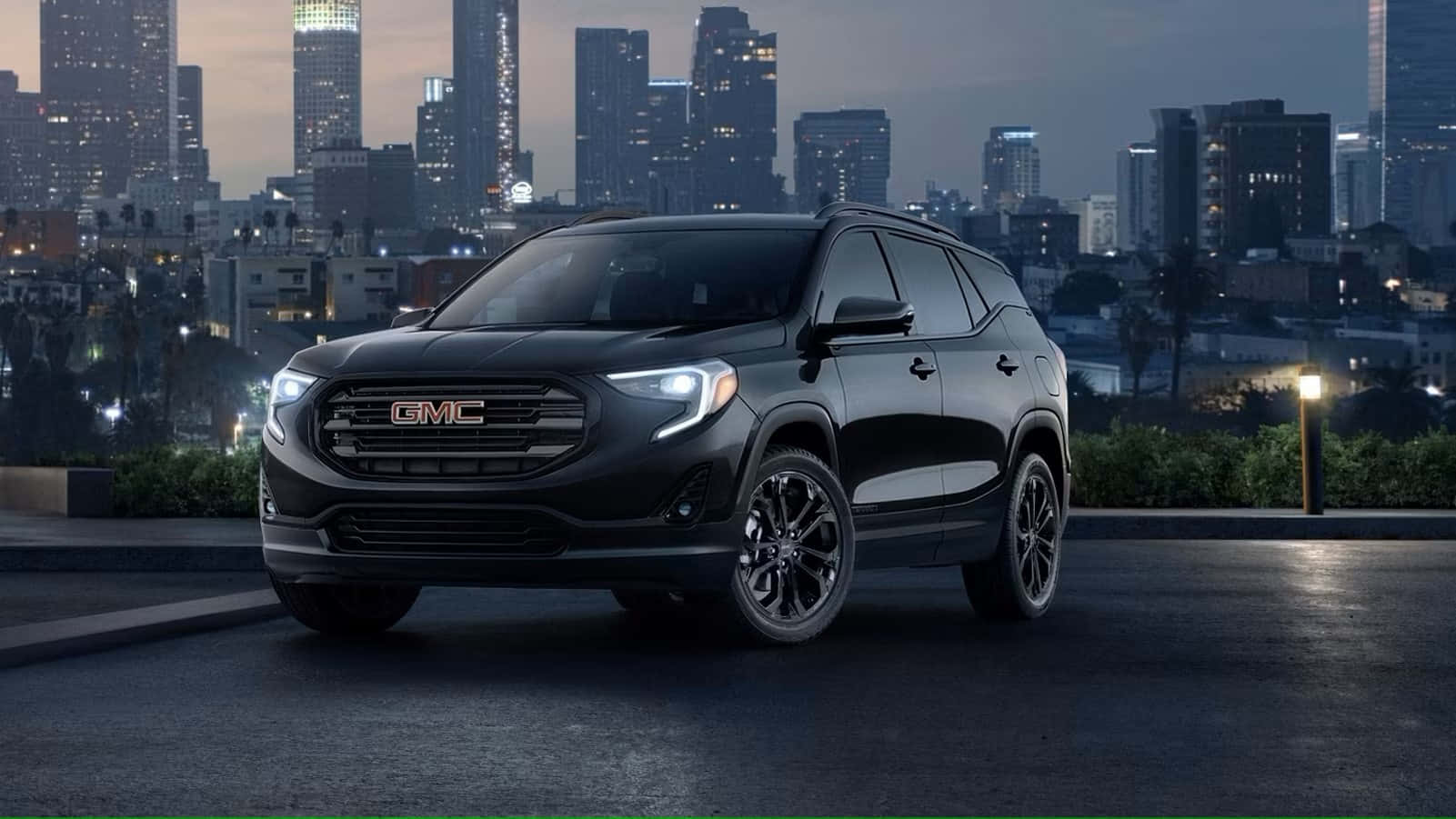 Gmc Terrain 桌布 壁紙 — 一輛時尚的黑色GMC SUV在黃昏時停在天台上，背後是閃爍的城市天際線。