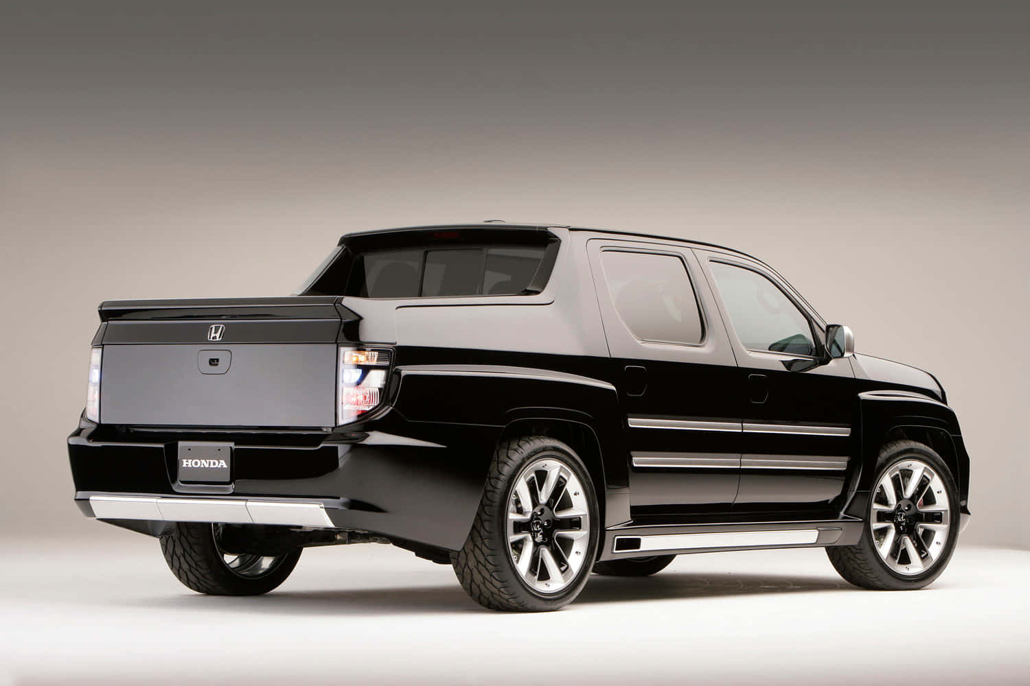 Honda Ridgeline 桌布 壁紙 — 一輛時尚的黑色本田皮卡車在攝影棚燈光下展示，帶有鍍鉻飾邊和大合金輪圈。