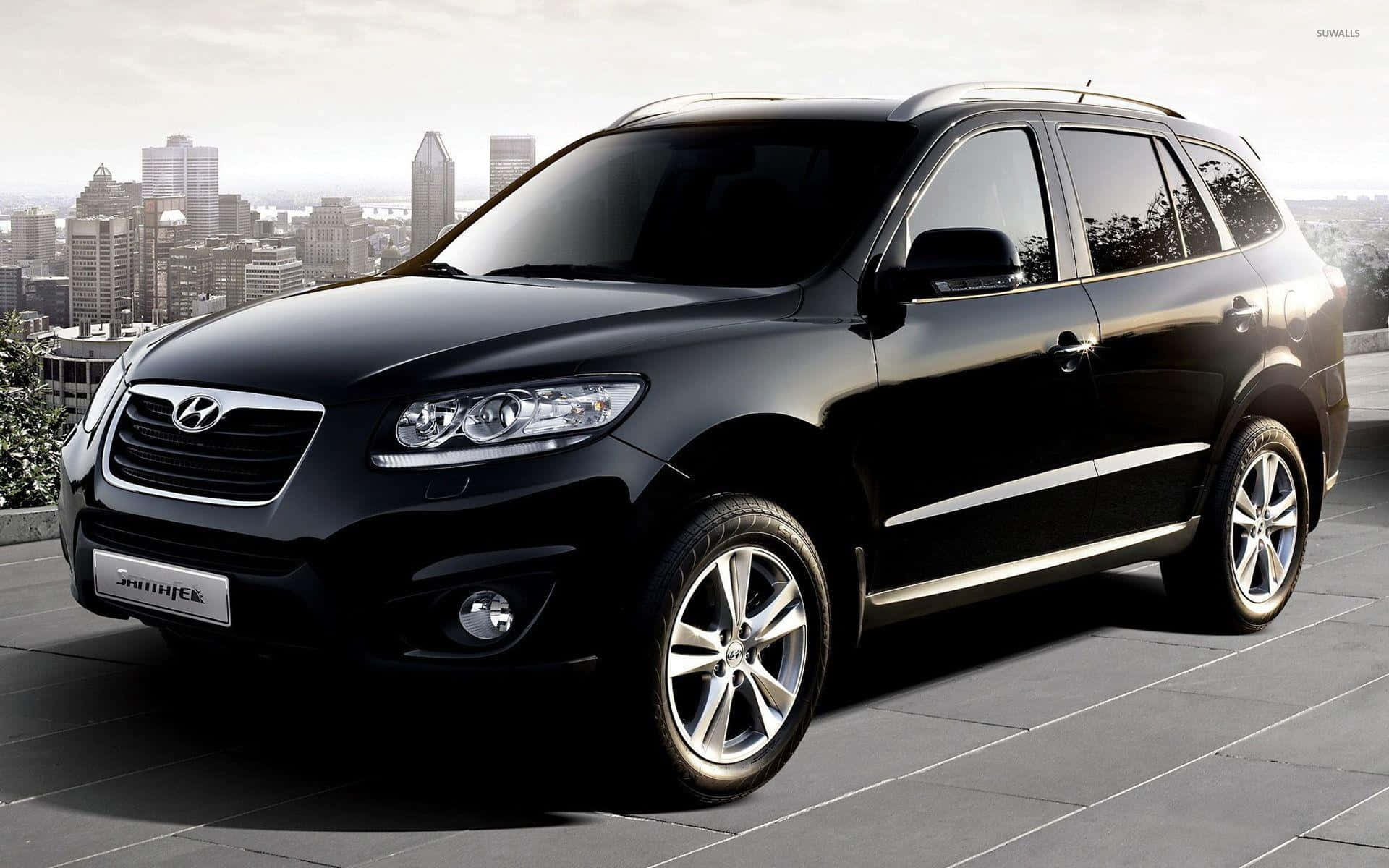 Hyundai Santa Fe 桌布 壁紙 — 一輛時尚的黑色現代Santa Fe SUV停放在瓷磚屋頂上，背景是城市天際線。