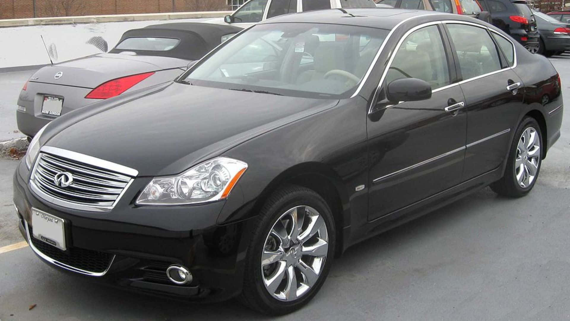 Infiniti M35 桌布 壁紙 — 一輛時尚的黑色Infiniti轎車停放在停車場，背景可見其他車輛。