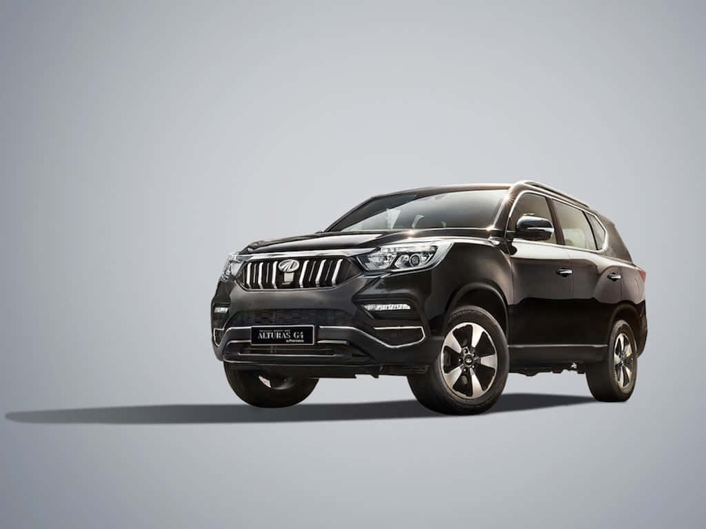  壁紙 — 一輛時尚的黑色Mahindra XUV500 SUV在簡約工作室環境中展示，配有柔和燈光和中性灰色背景。
