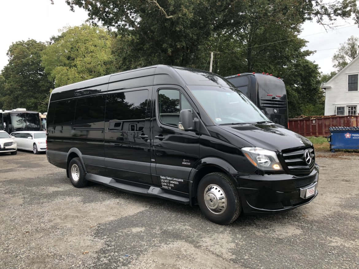 Mercedes Benz Sprinter 桌布 壁紙 — 一輛時尚的黑色 Mercedes-Benz Sprinter 客貨車停在碎石上，背景有樹木和其他車輛。
