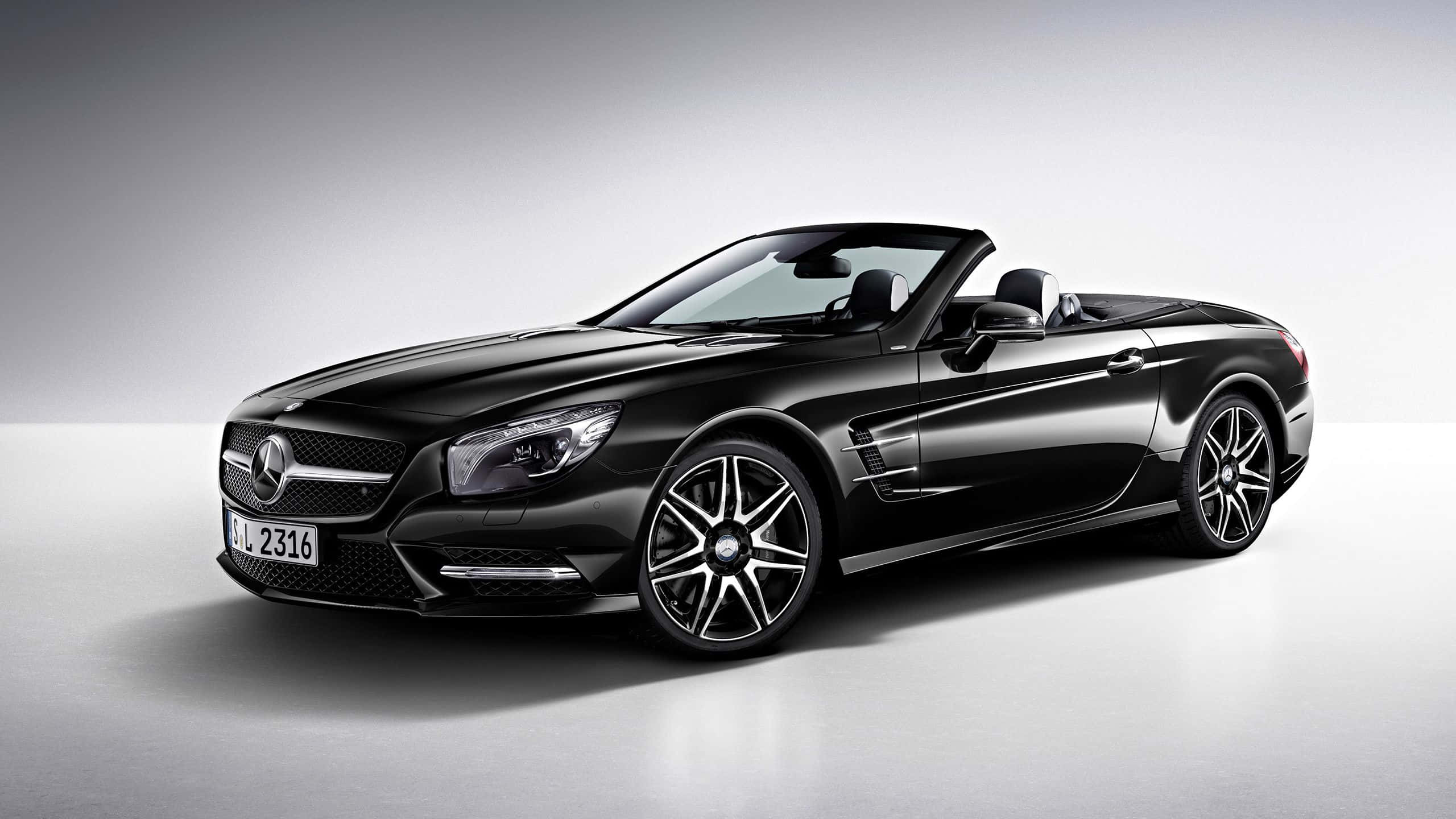 Mercedes Benz Sl-class 桌布 壁紙 — 一輛時尚的黑色梅賽德斯 SL 敞篷跑車配銀色輪圈，在簡約的攝影棚環境中展示。