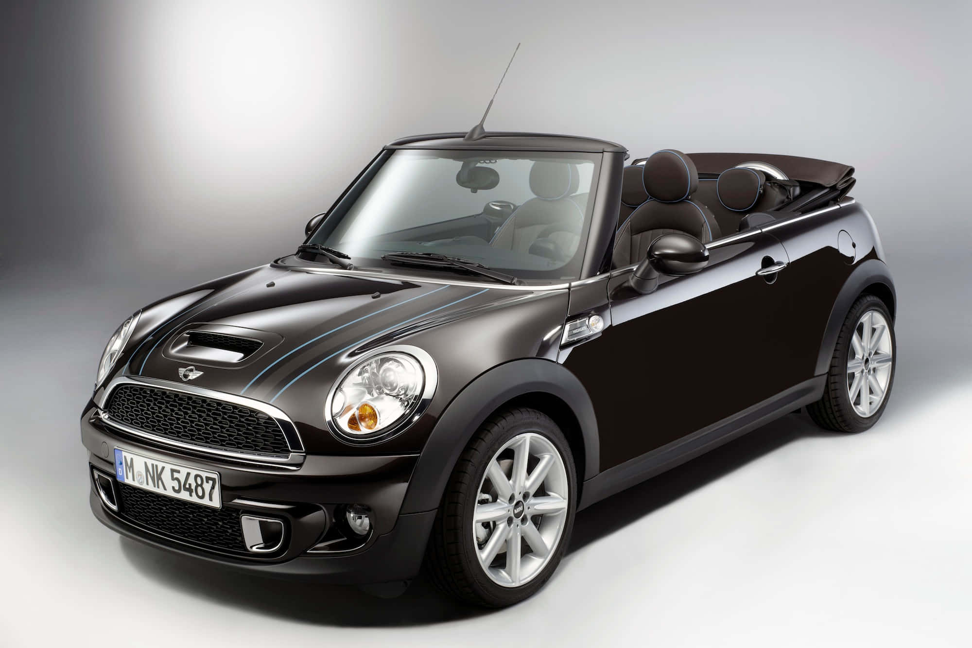 Mini Cooper Convertible 桌布 壁紙 — 一輛時尚的黑色MINI Cooper敞篷車，配備銀色輪圈和軟頂，在漸變灰色背景的攝影棚中擺拍。
