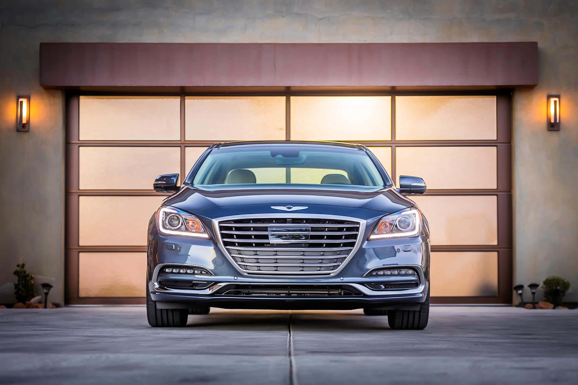 Genesis G80 桌布 壁紙 — 一輛時尚的藍色豪華轎車停在現代車庫前，帶有溫暖的環境照明。