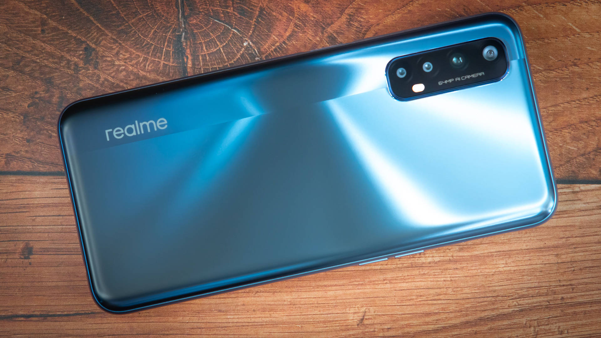 木桌上的藍色 realme 智慧型手機