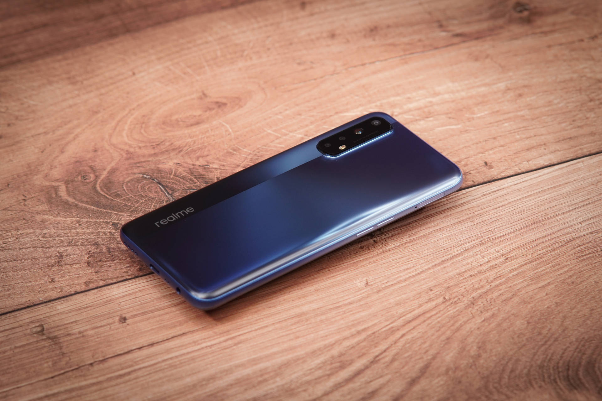 木桌上的藍色 realme 智慧型手機 — Realme 壁紙 壁紙
