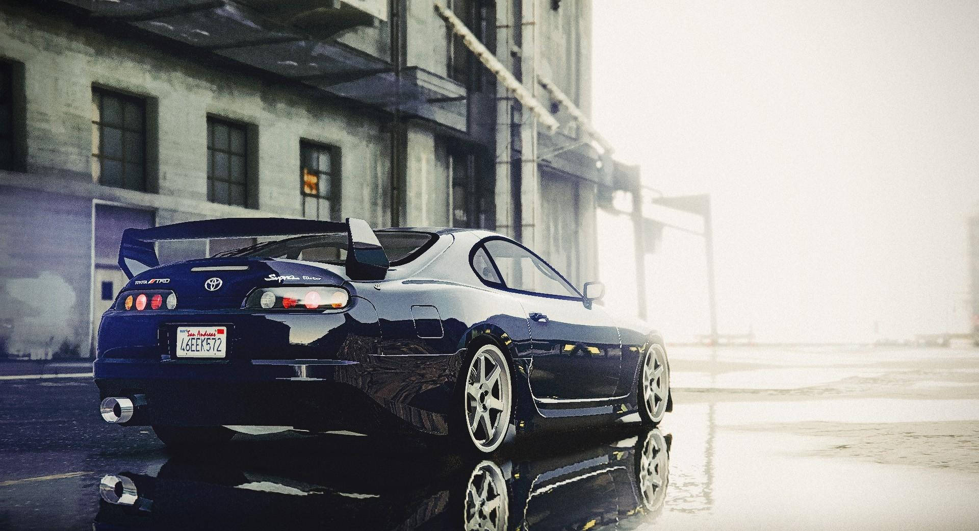 藍色跑車在黃昏時停在工業建築旁的潮濕路面上。 — Toyota Supra 壁紙