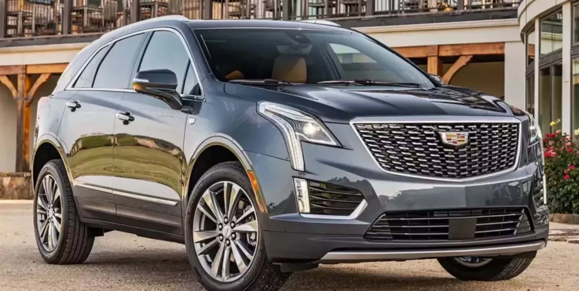 Cadillac Xt5 桌布 壁紙 — 一輛時尚的深灰色凱迪拉克SUV停放在戶外，具有反光表面和現代合金輪圈。