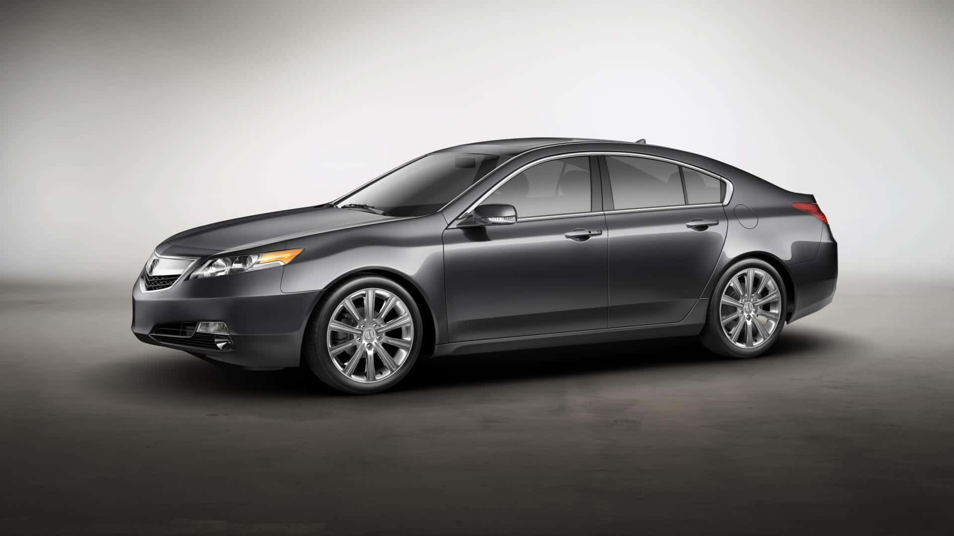Acura Tl 桌布 壁紙 — 一輛時尚的深灰色轎車配備鍍鉻輪圈，在簡約風格的攝影棚中以柔和燈光展示。