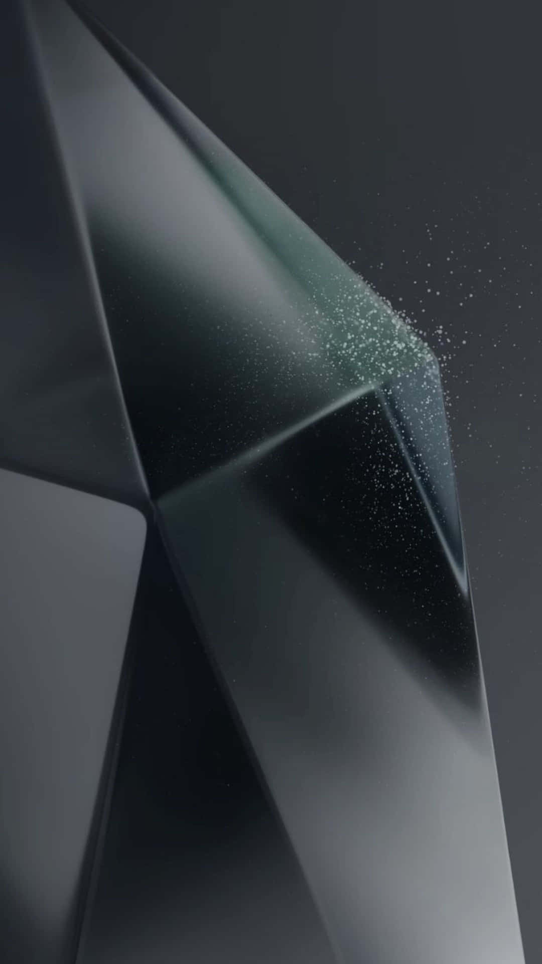 一個深色幾何水晶，帶有發光的綠色粒子從其邊緣飄散。 — Galaxy S10 壁紙
