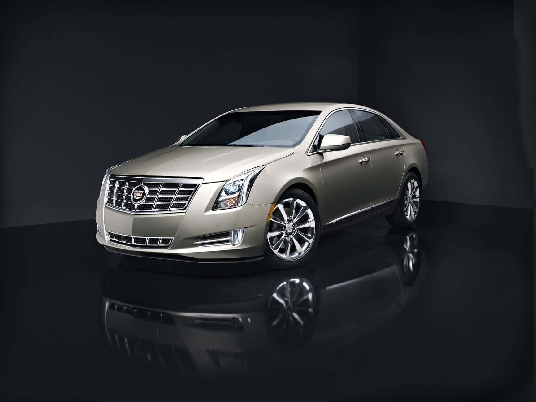 Cadillac Xts 桌布 壁紙 — 一輛時尚的金色凱迪拉克轎車在黑色反光地板上，於深色背景下在攝影棚燈光下閃閃發光。