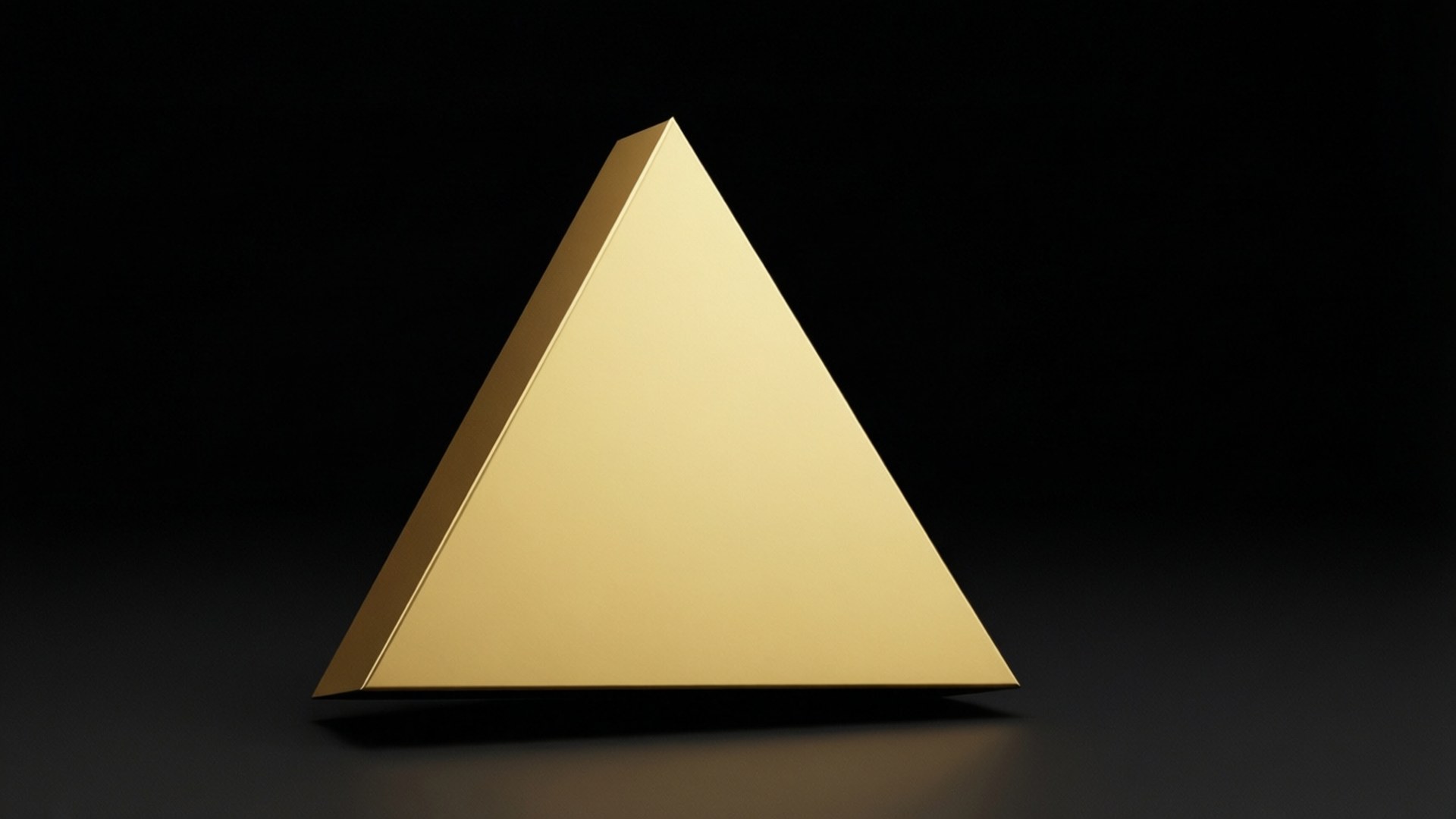 Shape 桌布 壁紙 — 一個光滑的金色金字塔放置在深色表面上，黑色背景，柔和燈光突出其幾何形狀。