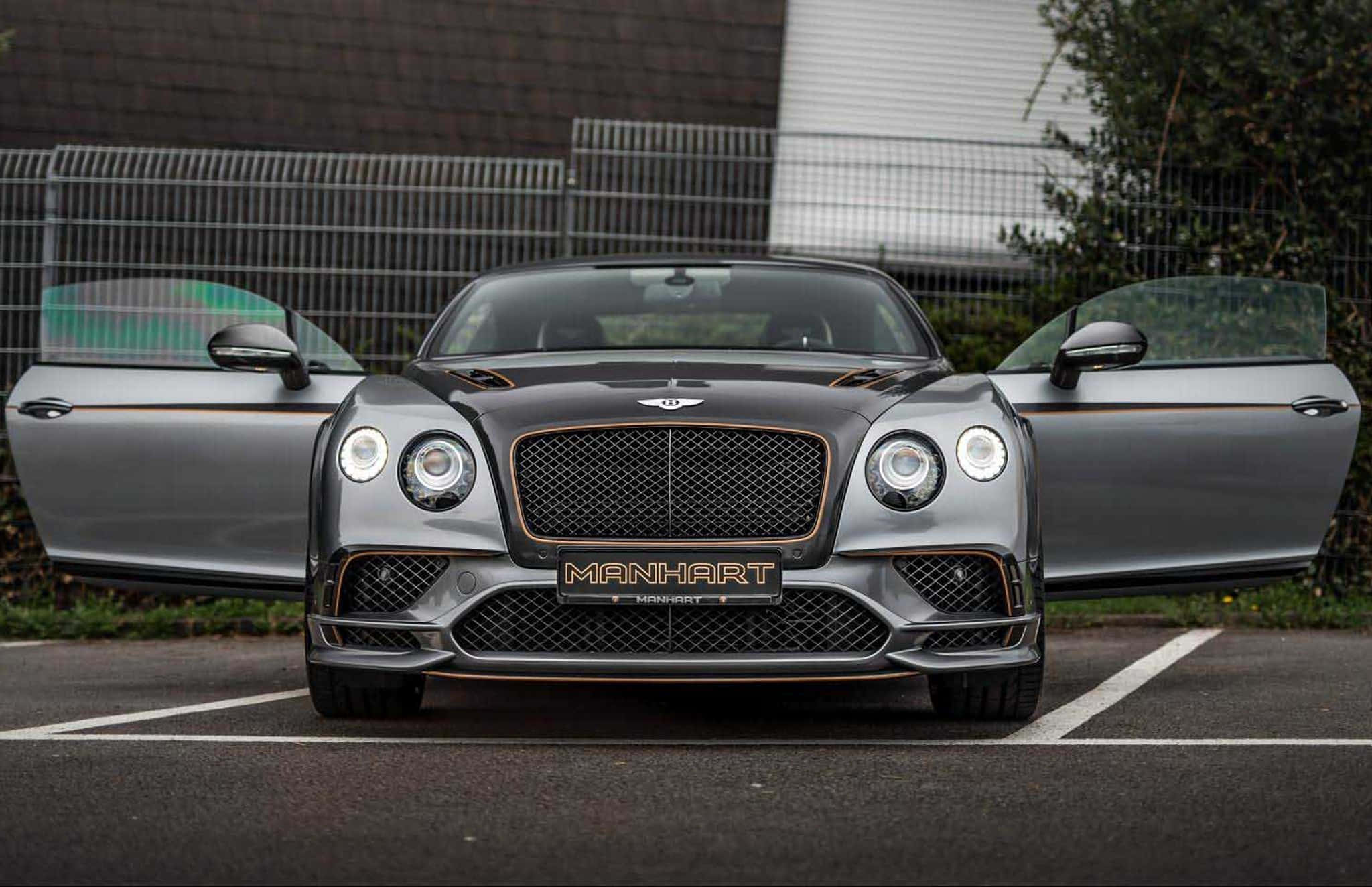 Bentley Continental Supersports 桌布 壁紙 — 一輛時尚灰色Manhart改裝的Bentley Continental GT打開車門停在瀝青停車場。