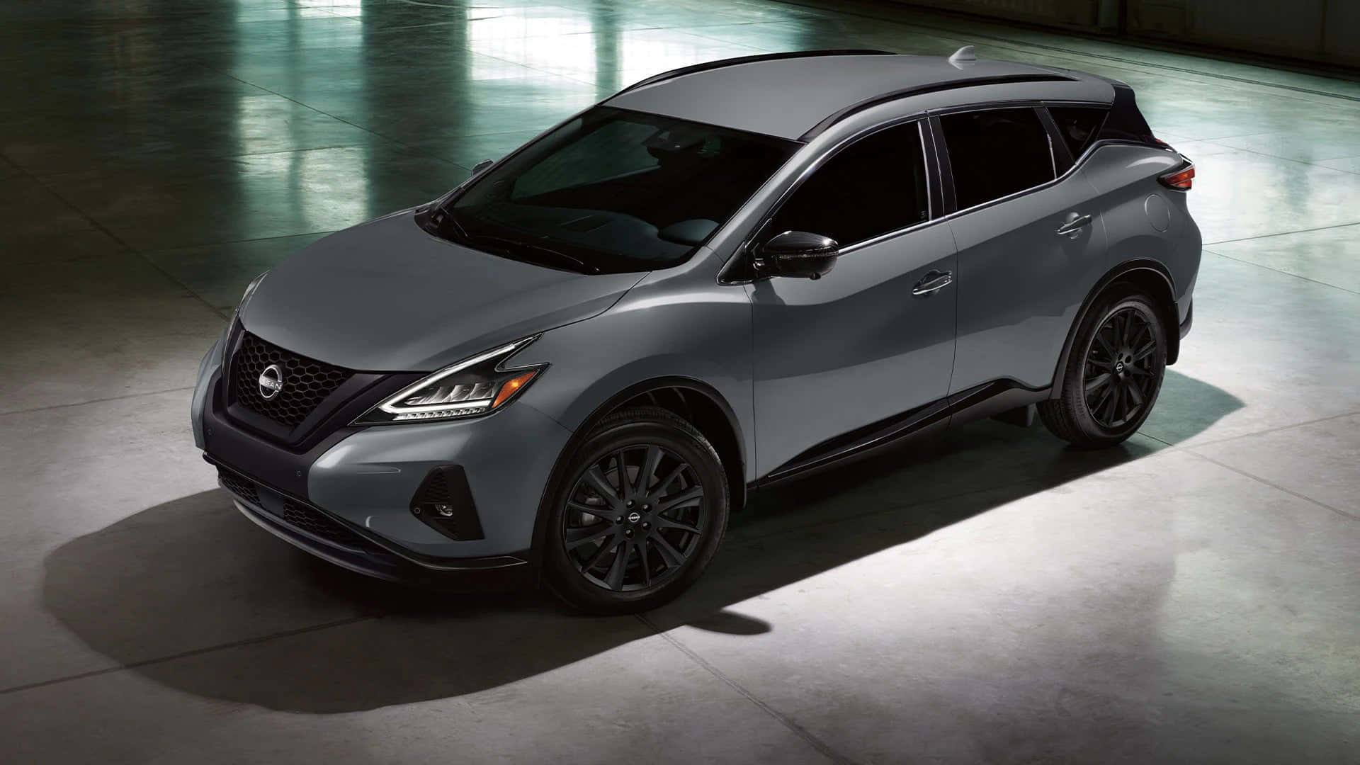 Nissan Murano 桌布 壁紙 — 一輛時尚的灰色日產Rogue SUV，帶有黑色飾邊，在拋光混凝土地板上，於戲劇性的工作室燈光下展示。
