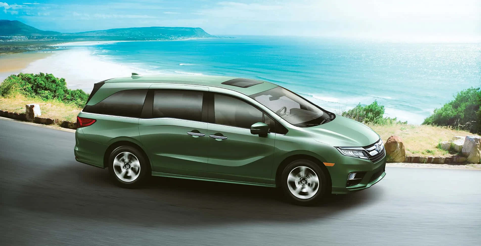 Honda Odyssey 桌布 壁紙 — 一輛時尚的綠色小型貨車沿著海岸道路行駛，碧綠的海浪拍打著沙灘，天空湛藍明亮。