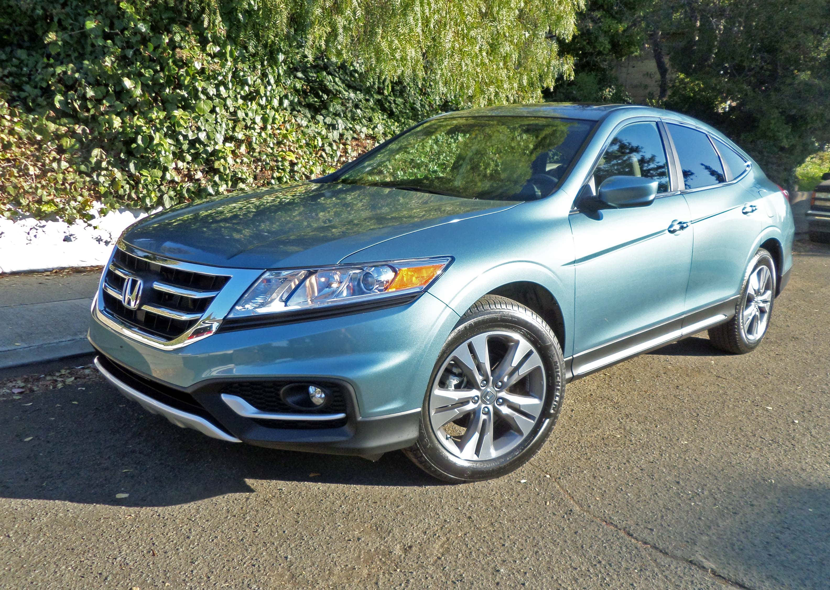 Honda Crosstour 桌布 壁紙 — 一架時尚的淺藍色本田 Crosstour SUV 停放在陽光普照的瀝青車道上，旁邊是茂密的綠色樹籬。