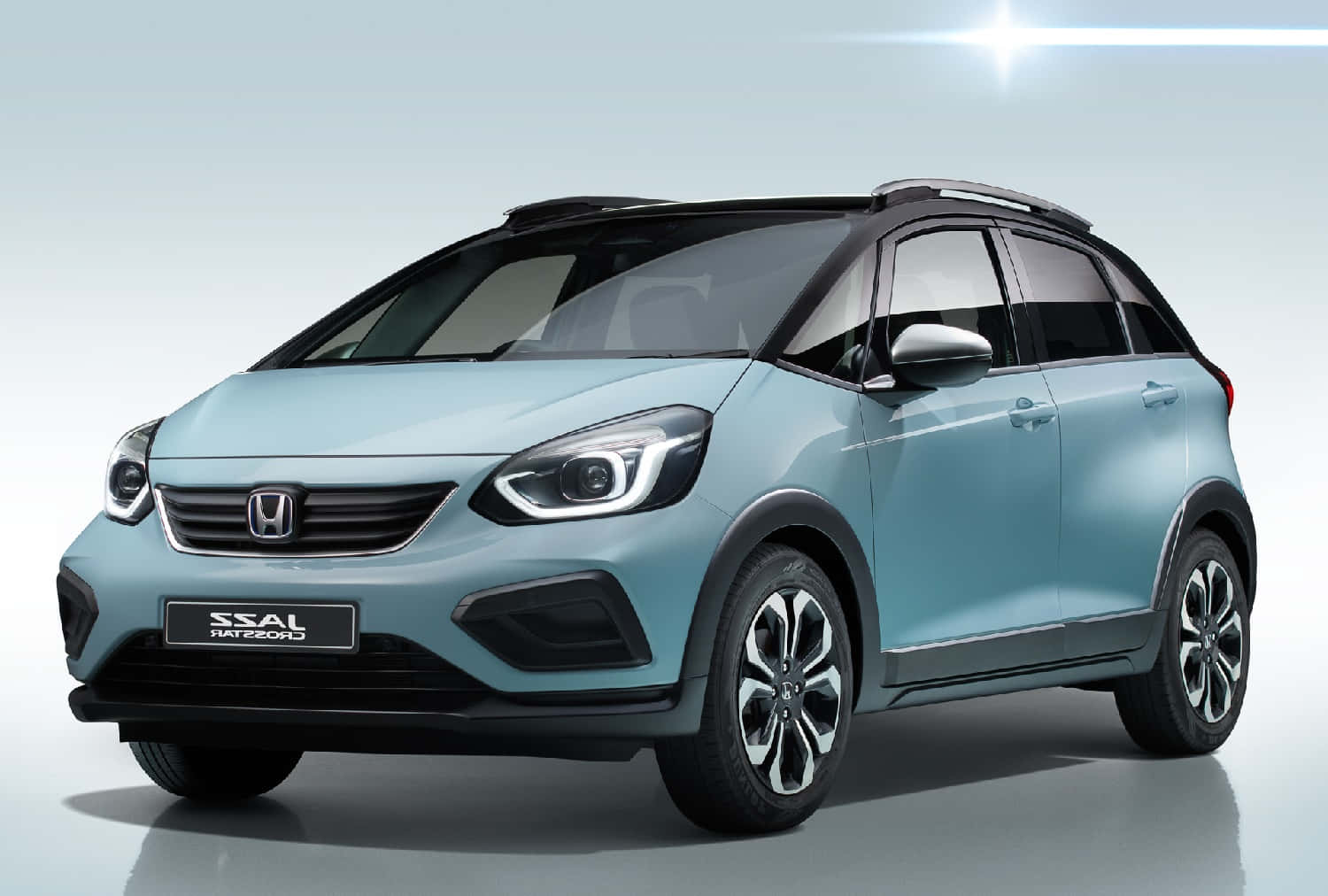 Honda Fit 桌布 壁紙 — 時尚淺藍色Honda e電動車，帶黑色飾邊和現代LED頭燈，置於乾淨的攝影棚背景前。