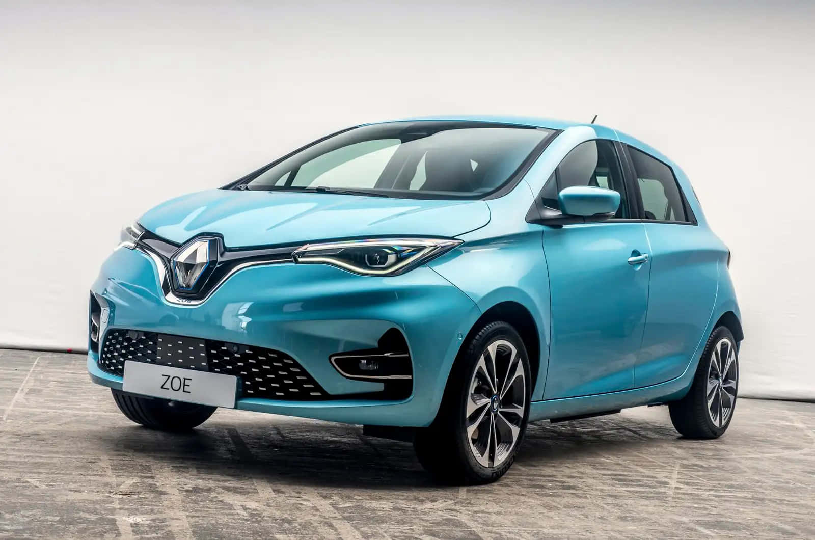 Renault Zoe 桌布 壁紙 — 一架時尚的淺藍色雷諾Zoe電動車在極簡主義工作室中展示，配有拋光混凝土地板和白色背景。